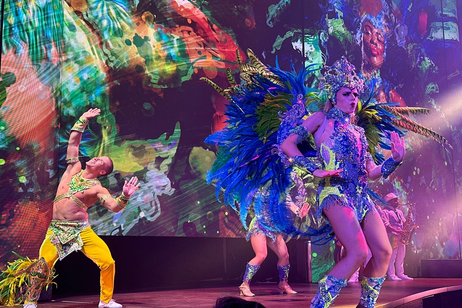 Performers in bright costumes perform on a cruise ship