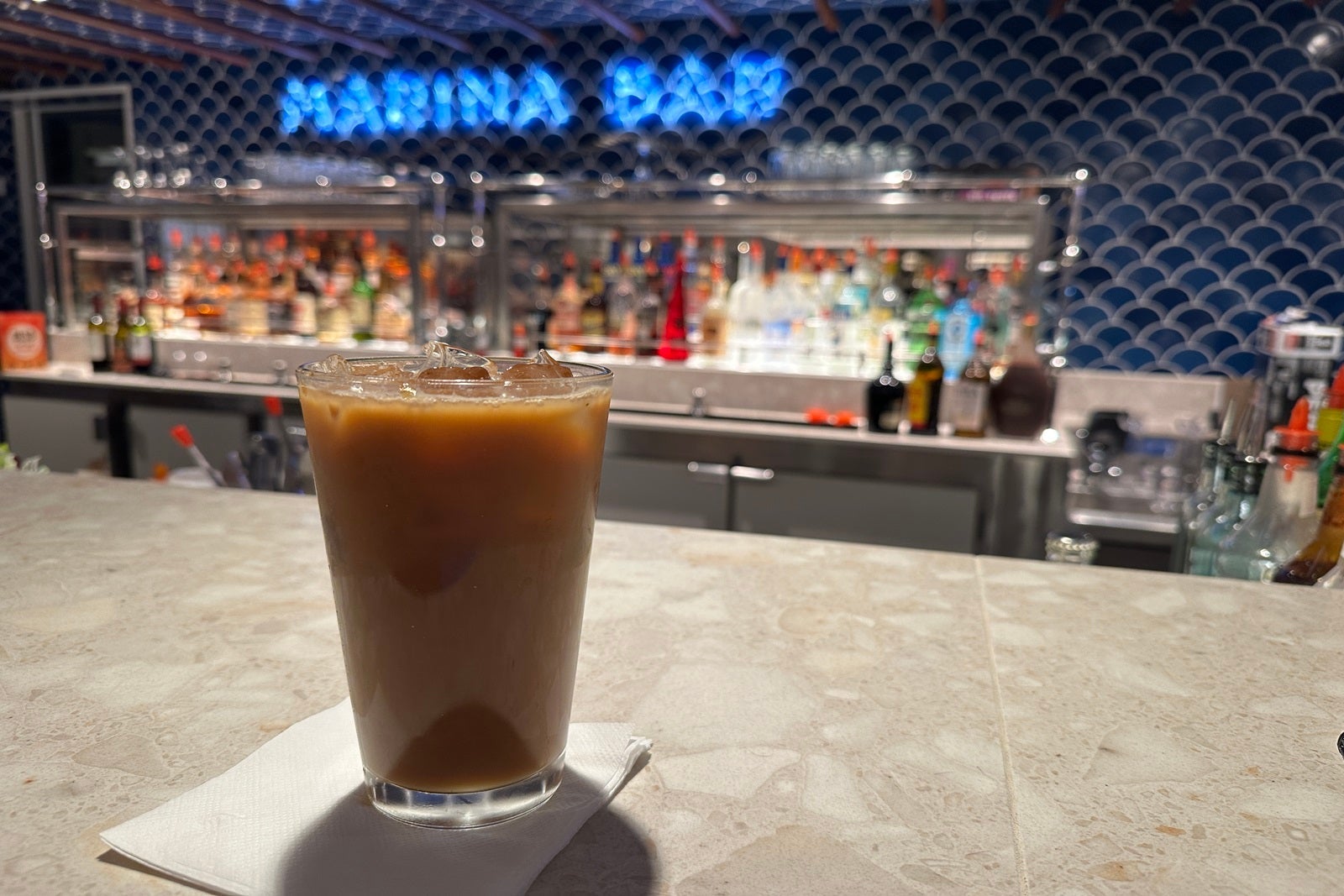 A glass of iced coffee on a bar counter