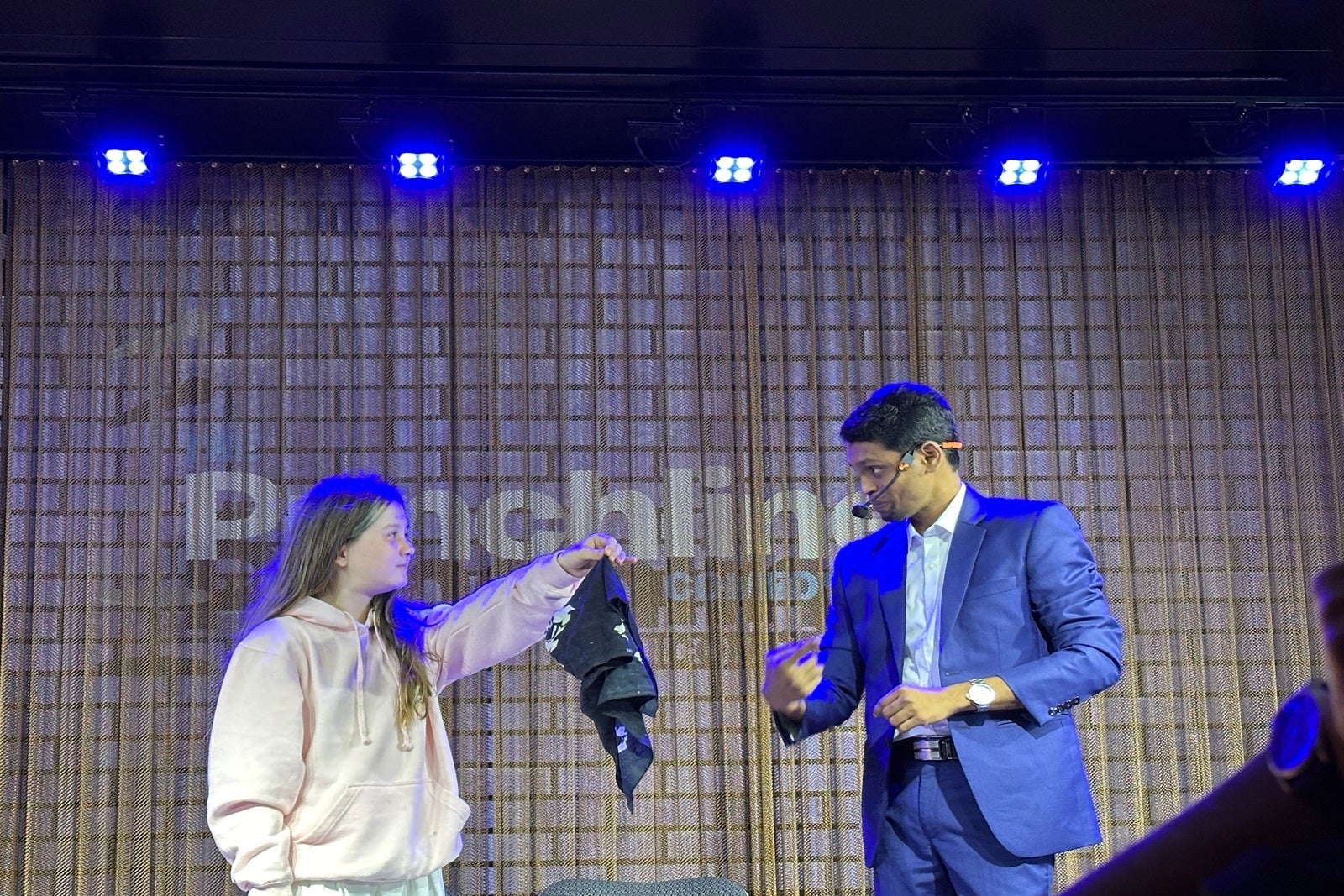 A cruise passenger helps a magician perform a trick