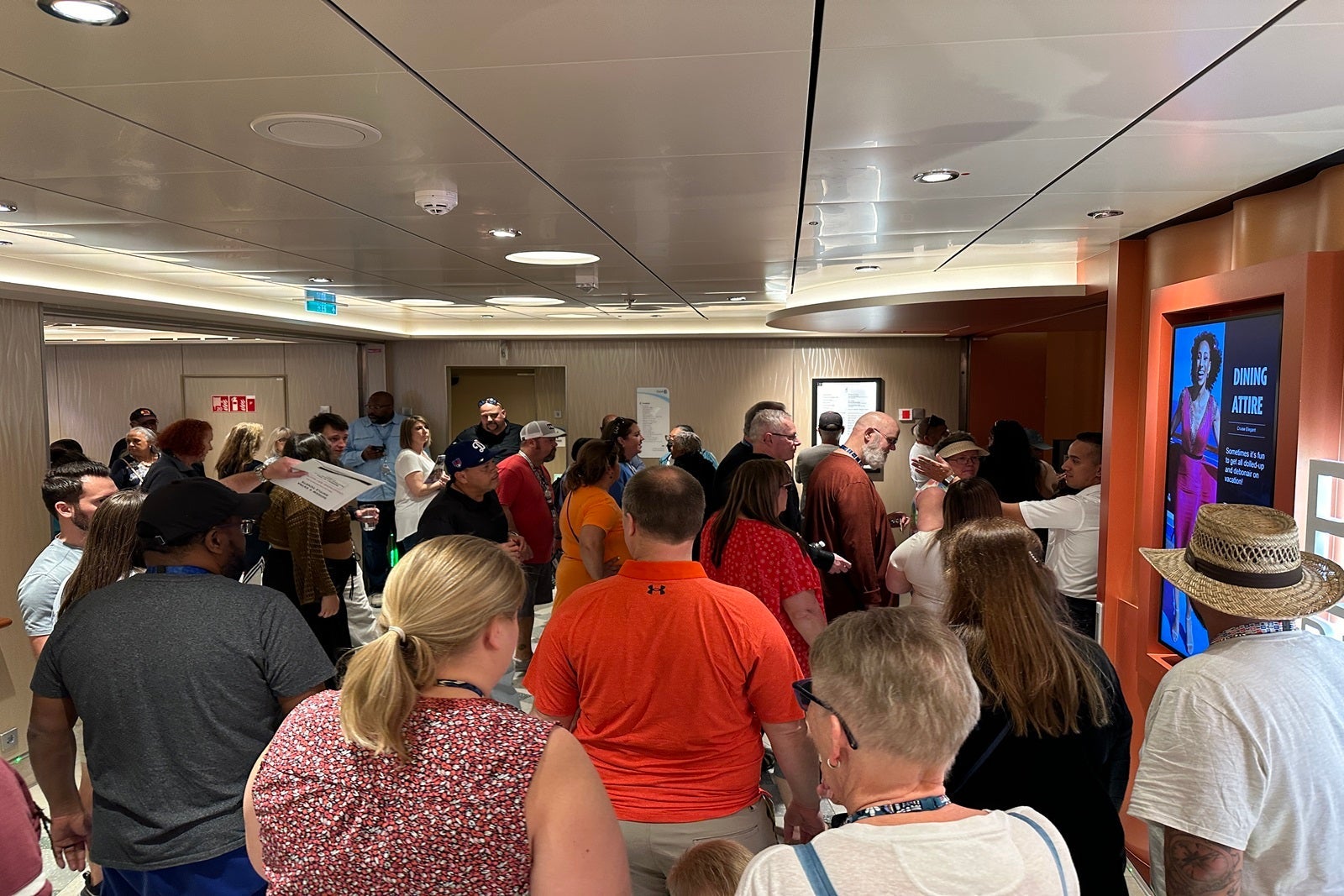 A crowd gathered in a cruise ship corridor