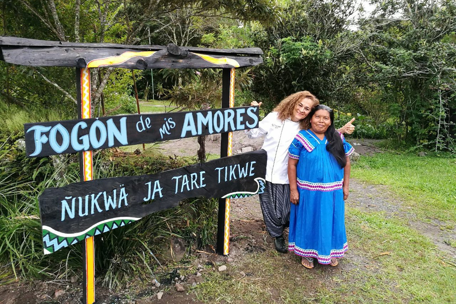 women in front of fogon de mis amores sign