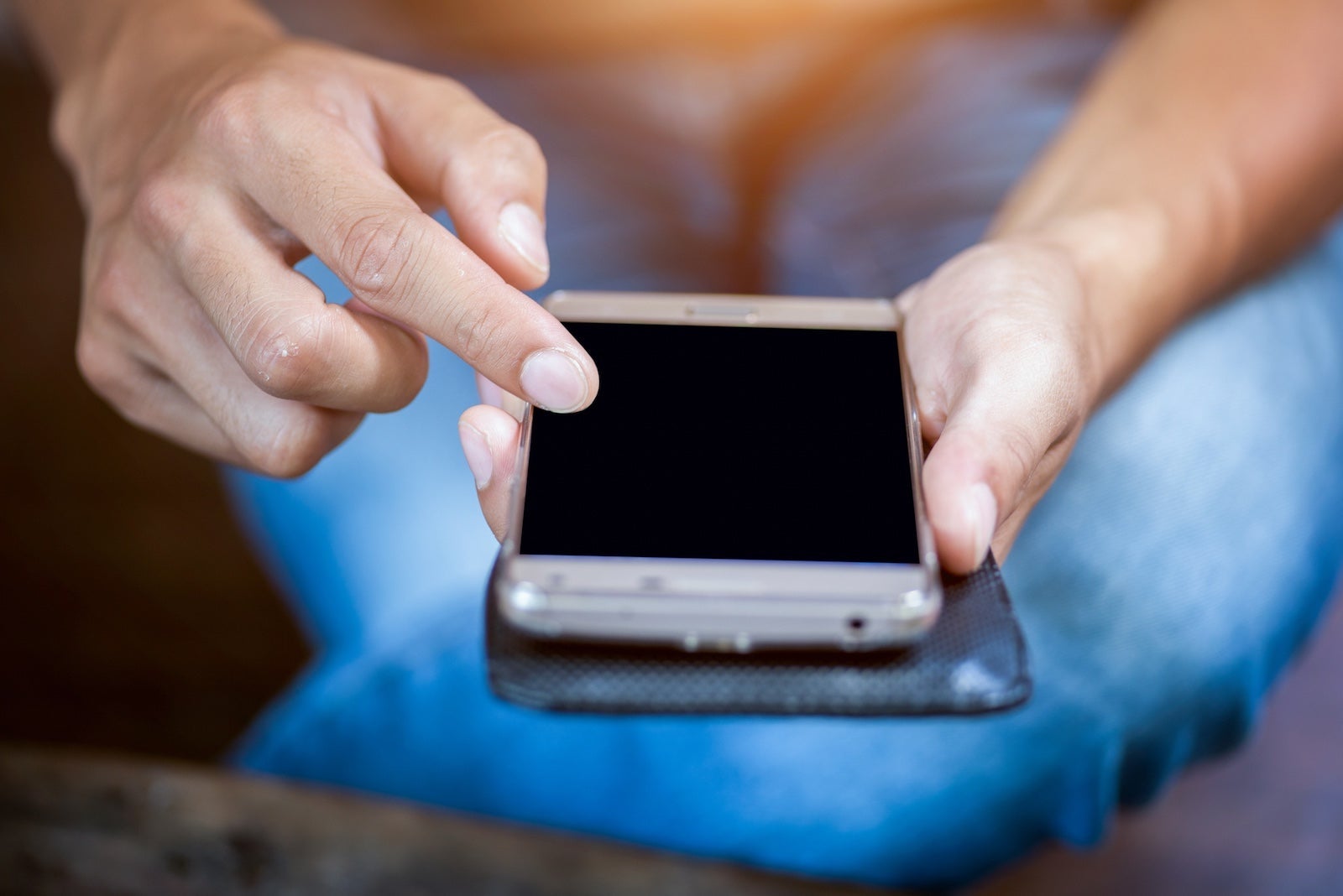 Close up of a woman hand using a smart phone on a desk at home