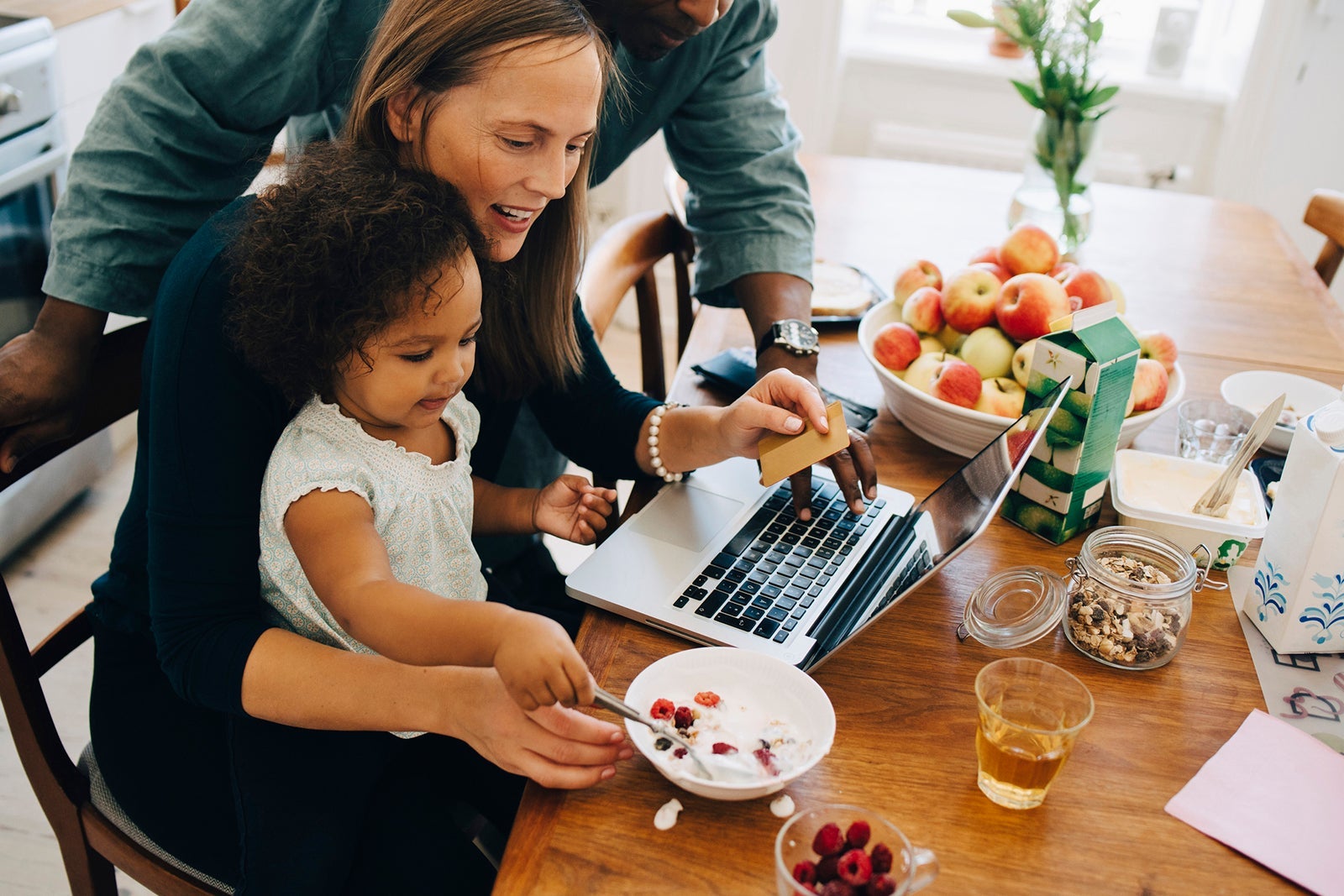 Best ways to earn airline miles: From online shopping to credit cards Parents shopping online with credit card while child is having breakfast at dining table Maskot