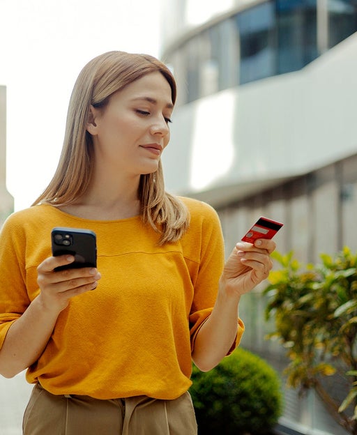 Woman holding card and phone