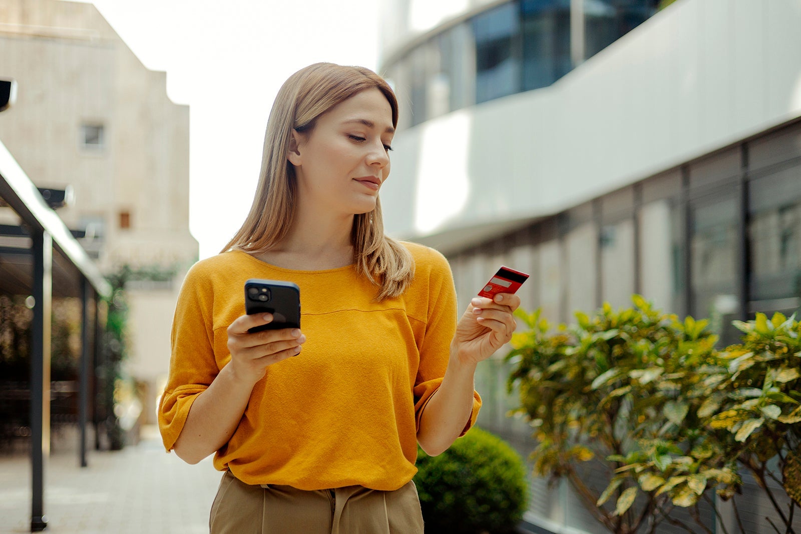 Woman holding card and phone