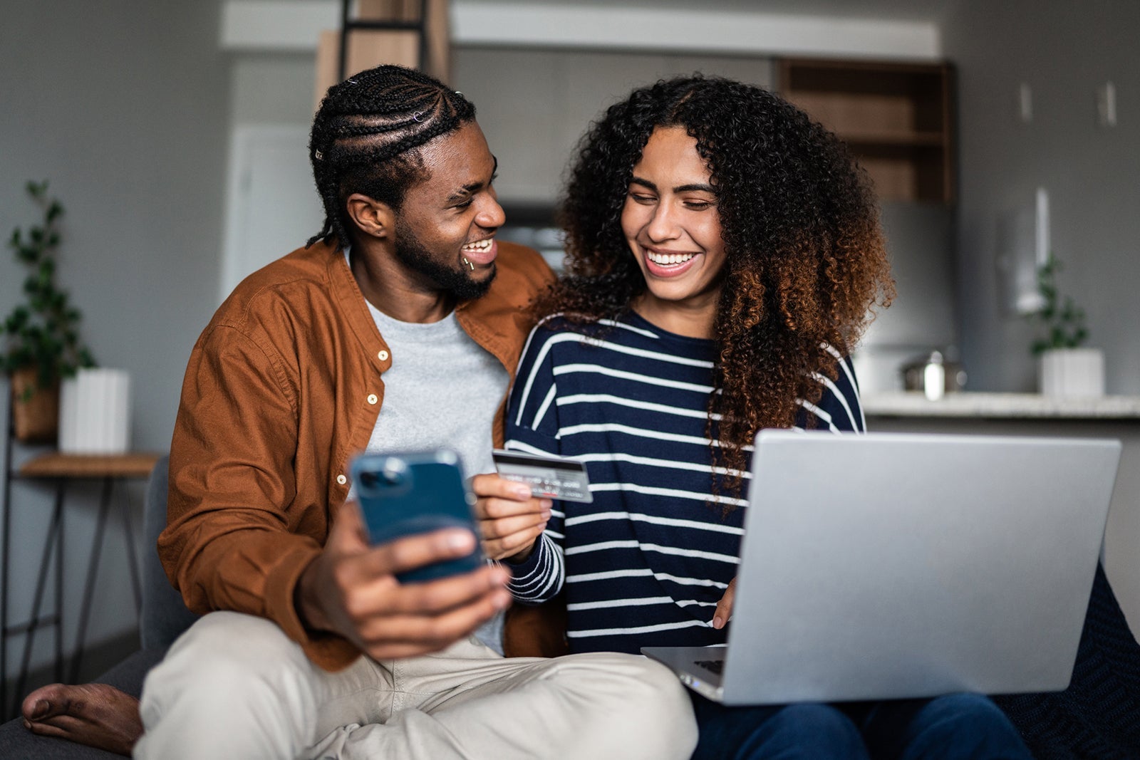 How I manage credit card redemption analysis paralysis Young couple online shopping using mobile phone and laptop at home