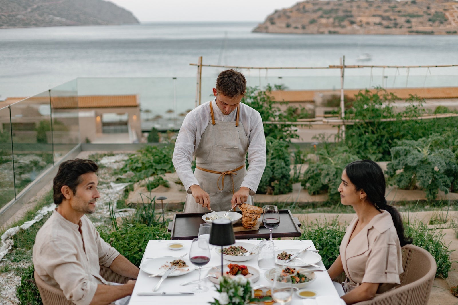 Two people dining and a waiter at the table