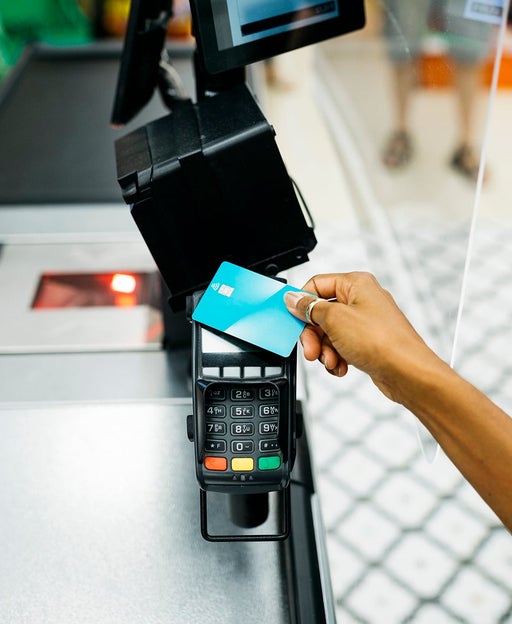 Close up of a hand paying with a credit card in a supermarket