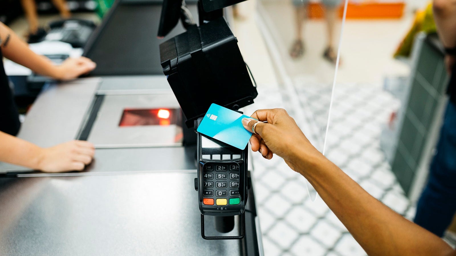 Close up of a hand paying with a credit card in a supermarket