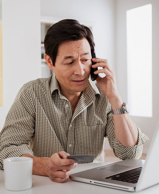 man talking on phone while on laptop