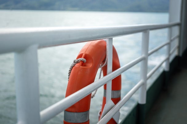 A rescue lifebuoy on ship corridor rail - Emergency equipment.