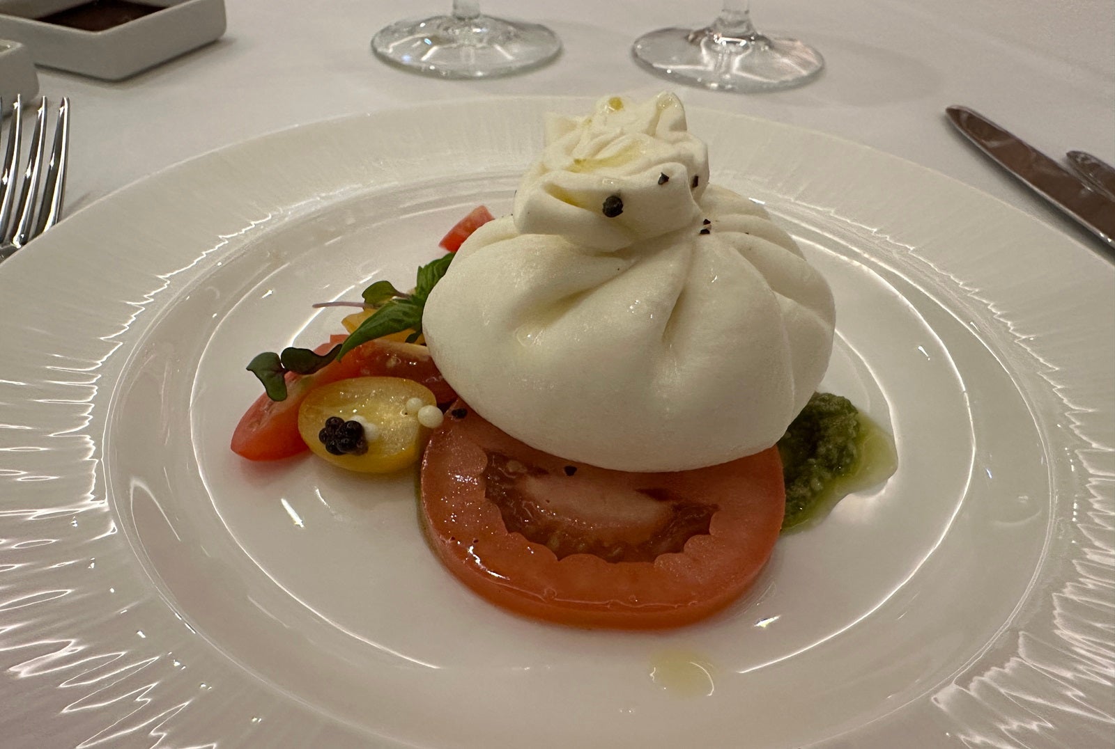 Burrata on a white plate with tomatoes