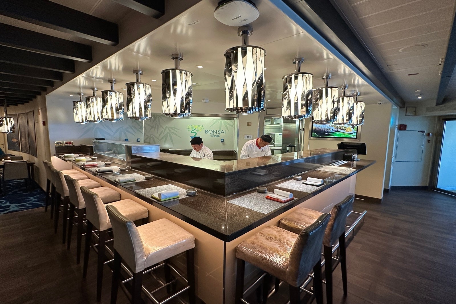 A sushi counter with two chefs behind it