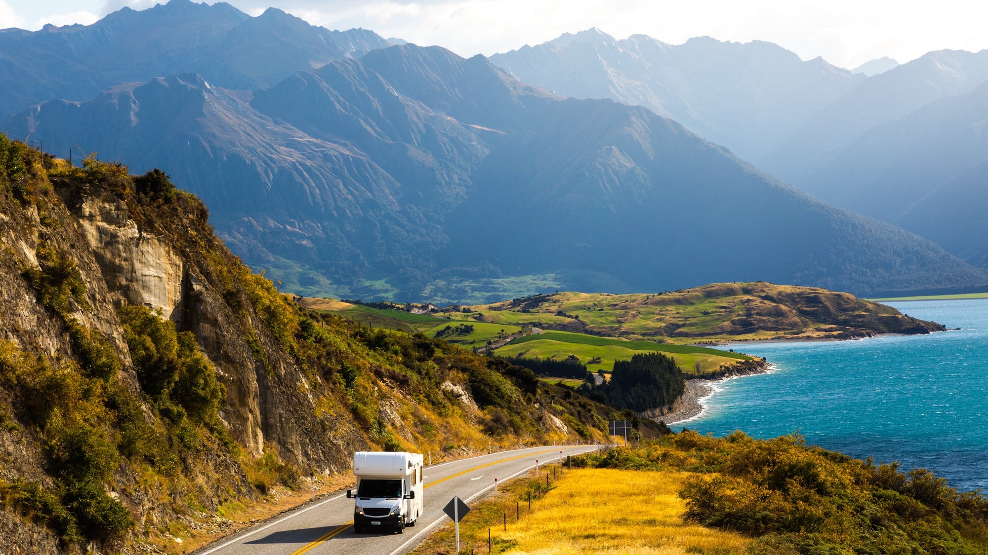 Campervan driving through scenic New Zealand mountains and lake
