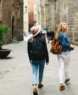 Spain, Barcelona, two young women walking in the city
