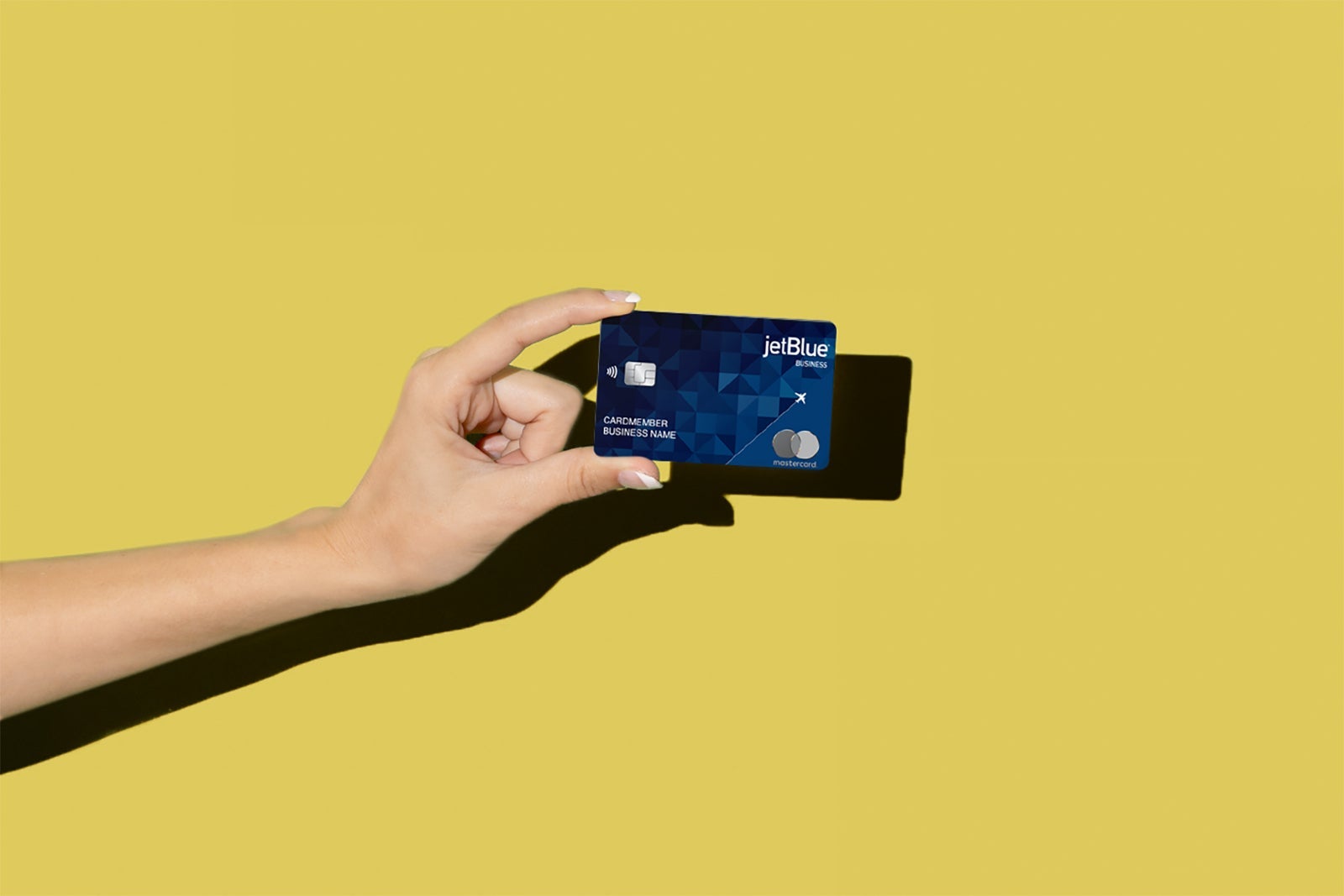 A hand holds a credit card