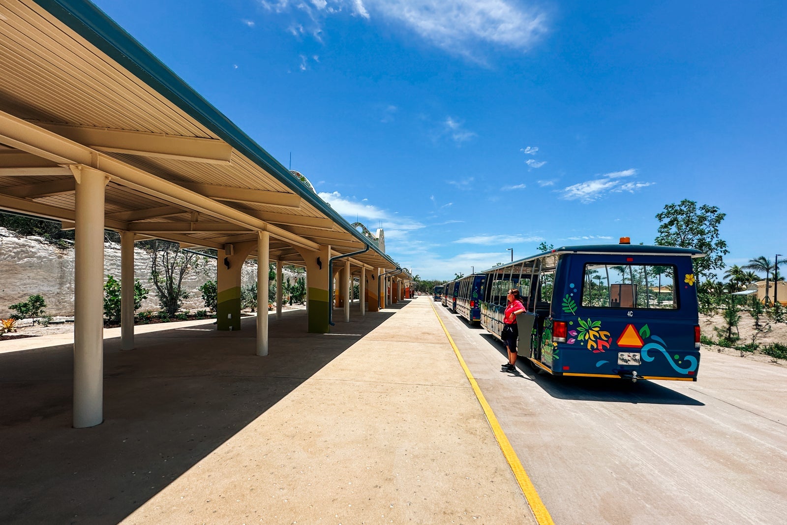 A shuttle waits next to a shaded pavilion