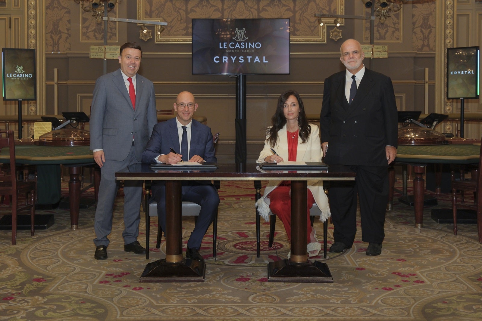 Cruise line and casino executives sitting at a table signing a contract