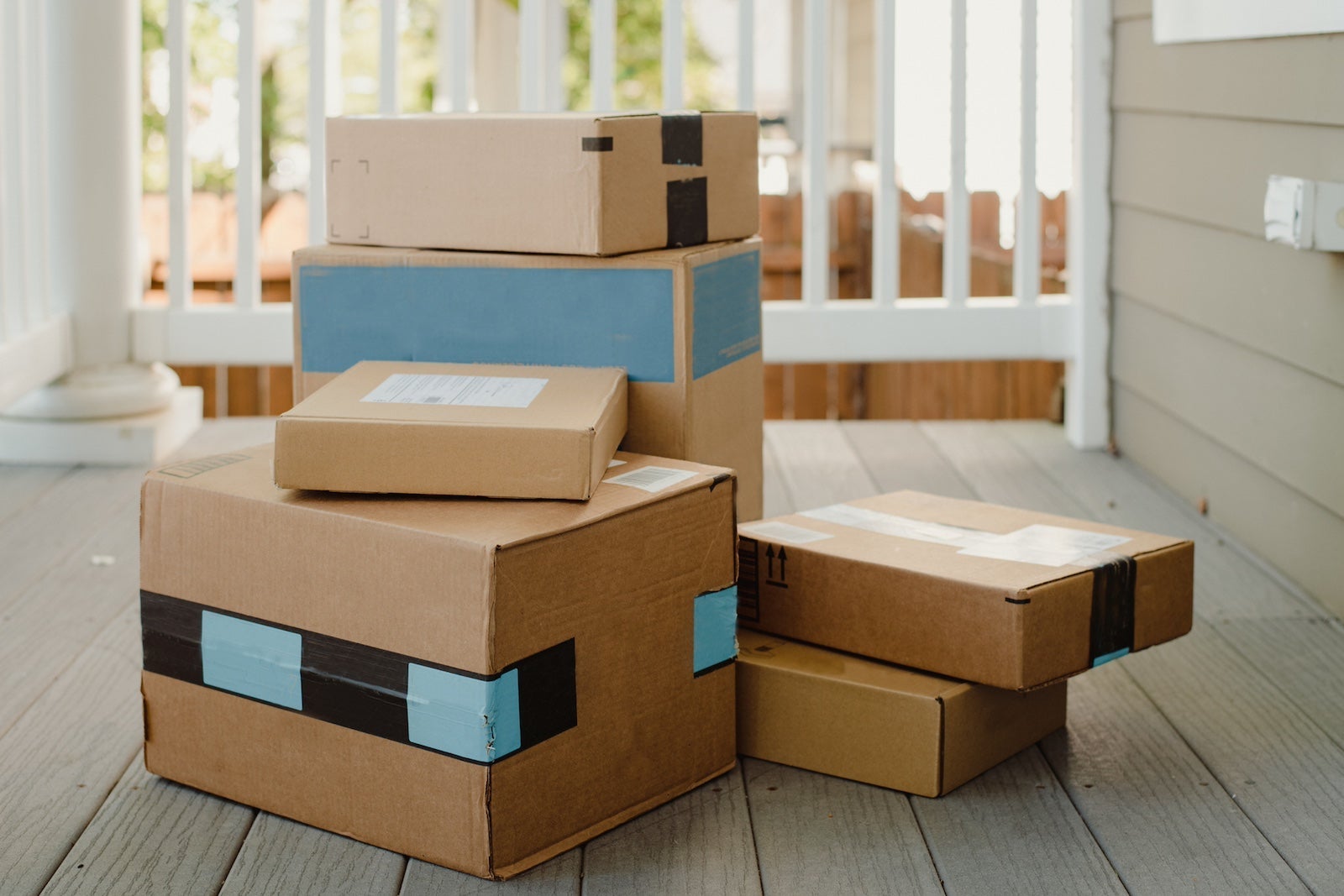 A stack of Amazon packages on a porch