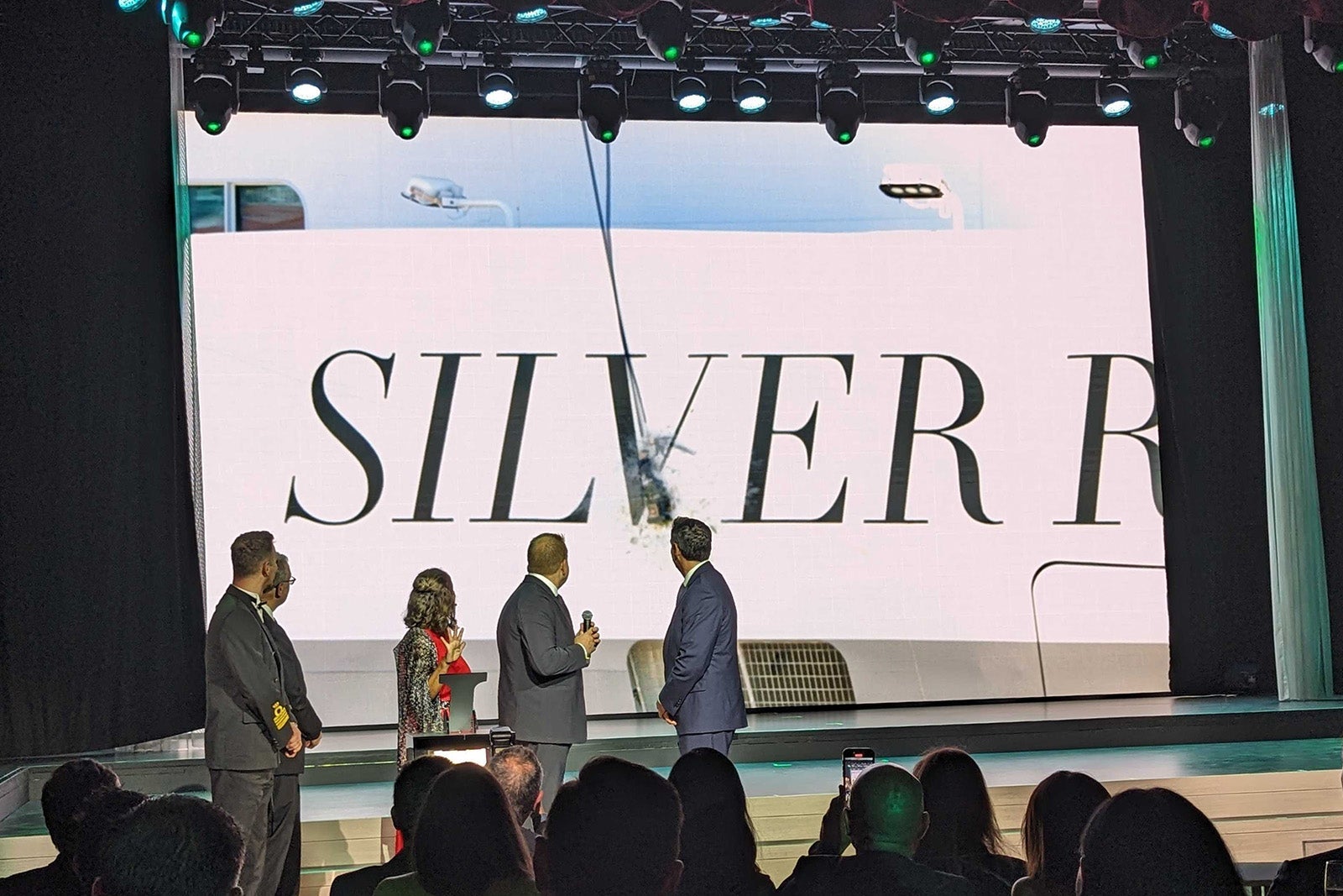 Executives watching cruise ship champagne bottle smash