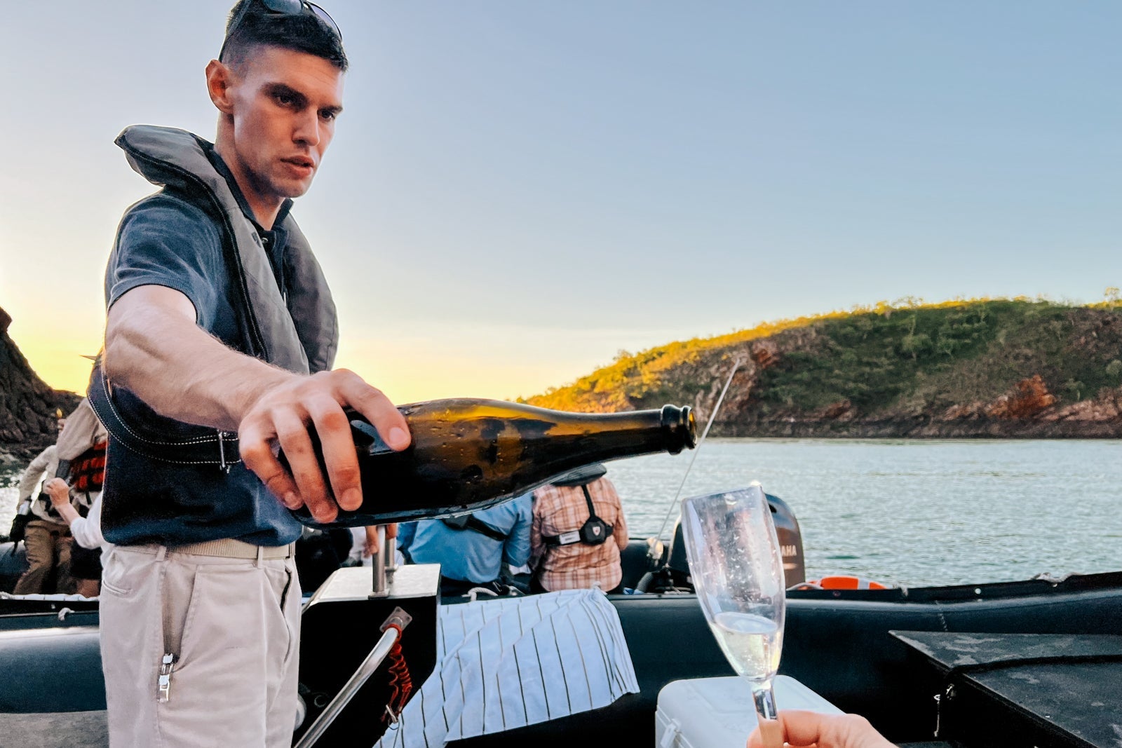 A Seabourn Pursuit crew member delivers Champagne to passengers during a Zodiac outing