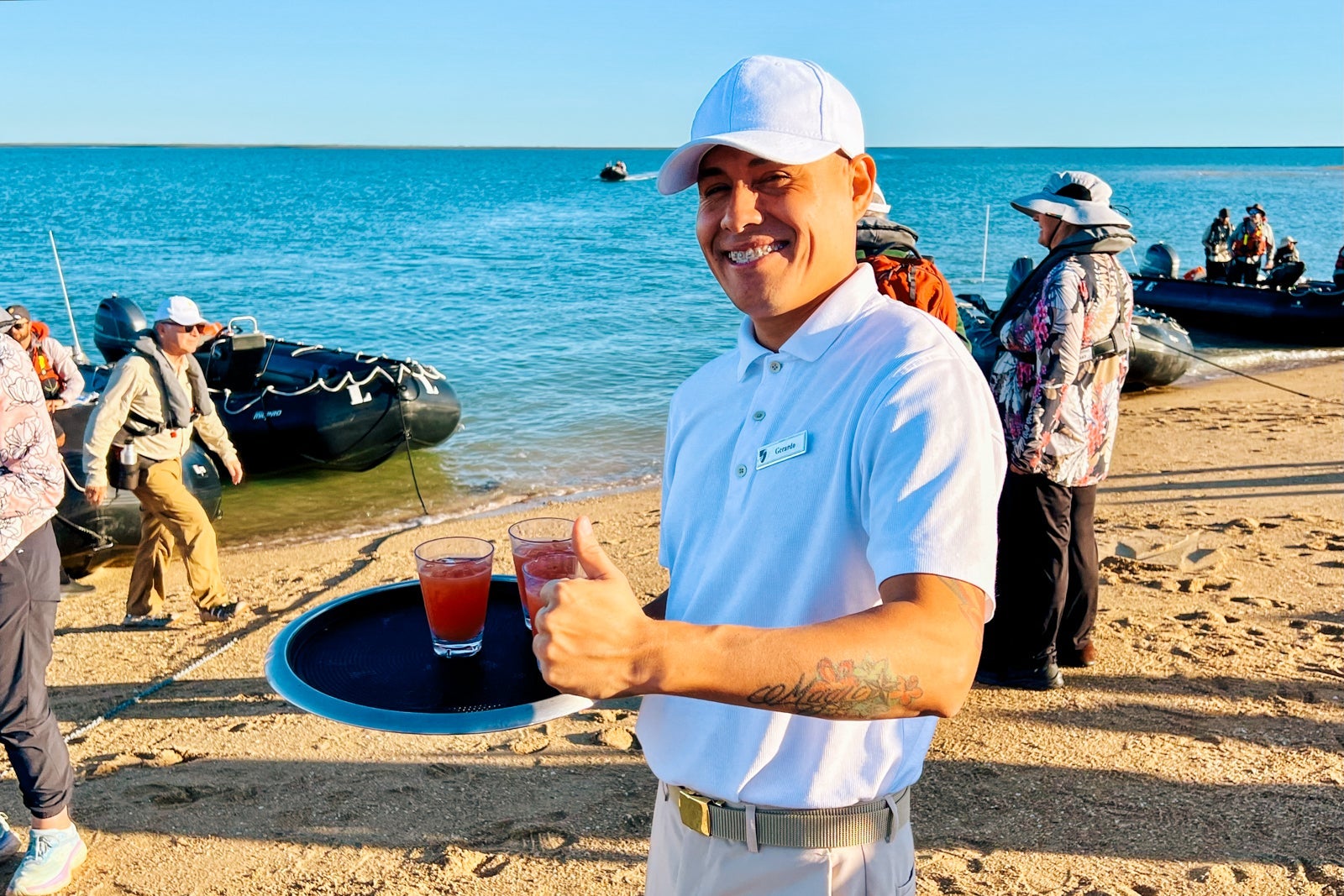A waiter serves drinks on a sand bar at Montgomery Reef
