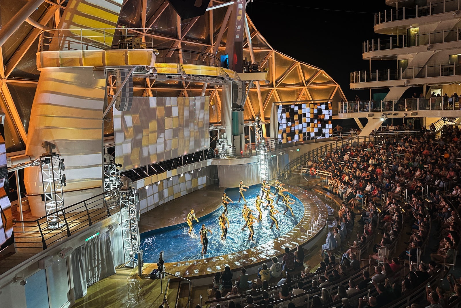 An outdoor high-dive pool and seating on a cruise ship