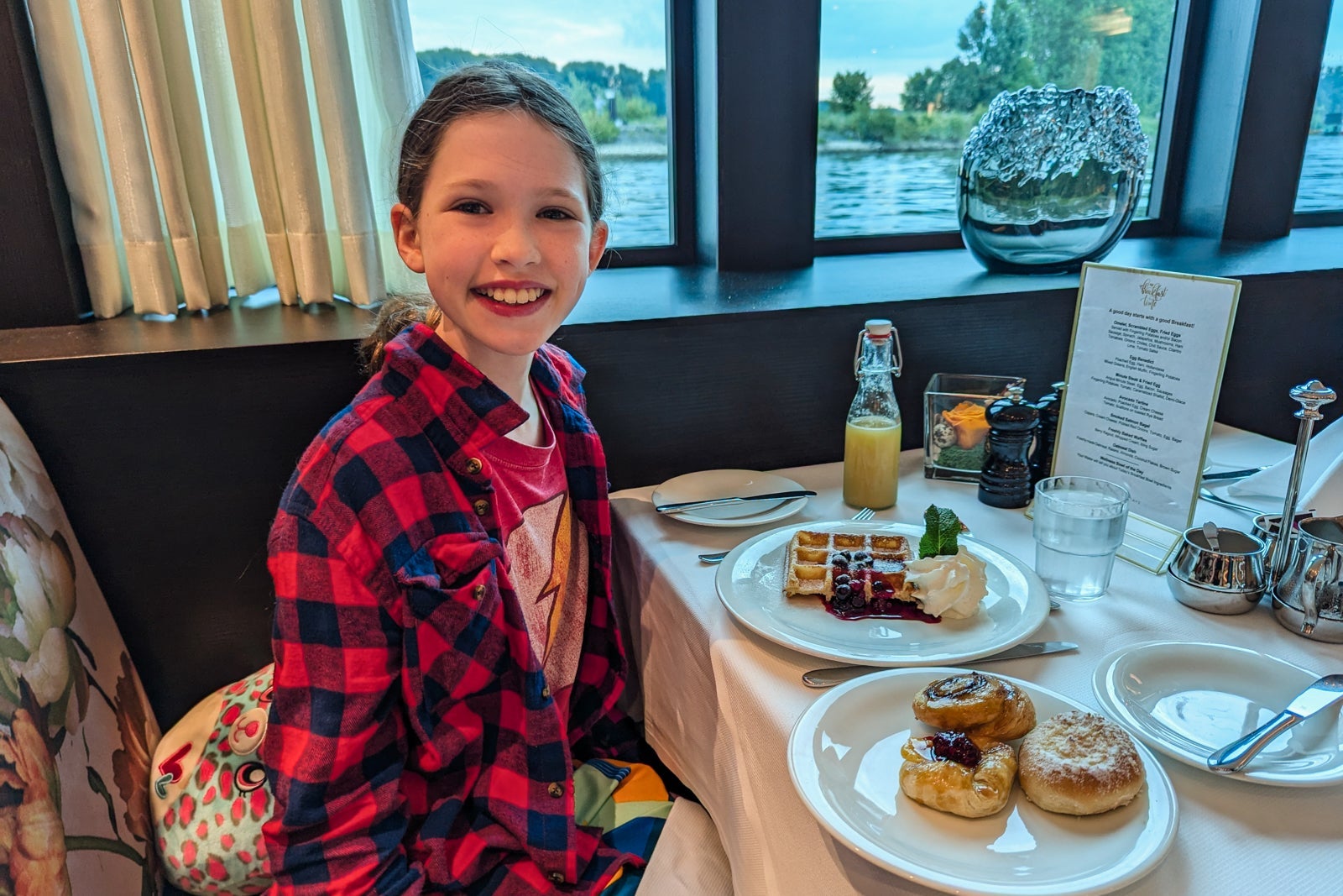 Girl on river ship eating waffles and pastries for breakfast