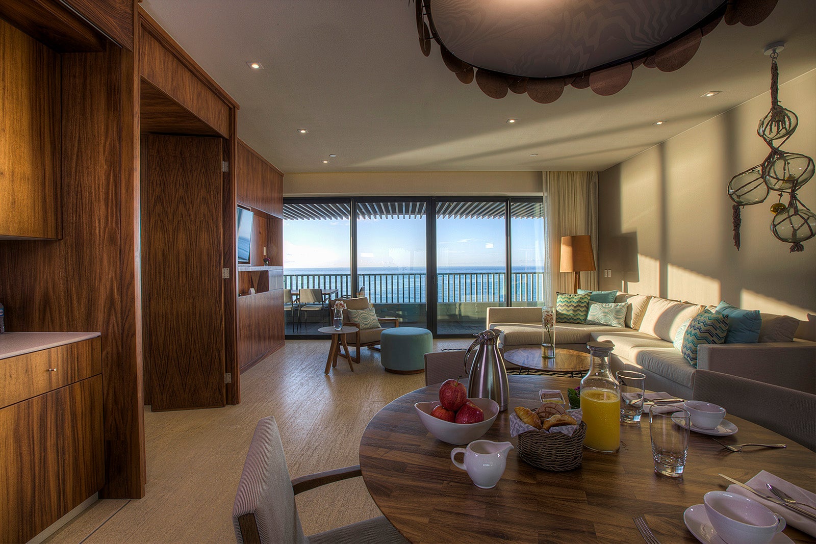 table with breakfast spread inside hotel room overlooking ocean