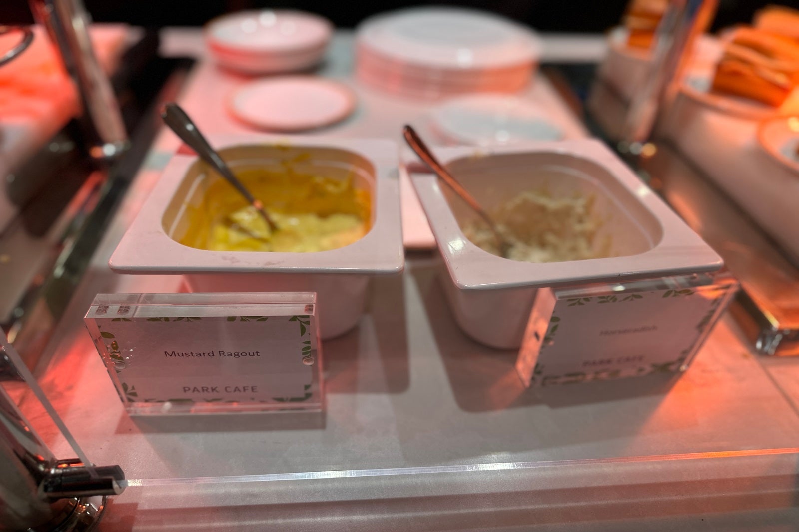 Two white serving dishes, one with mustard and one with horseradish