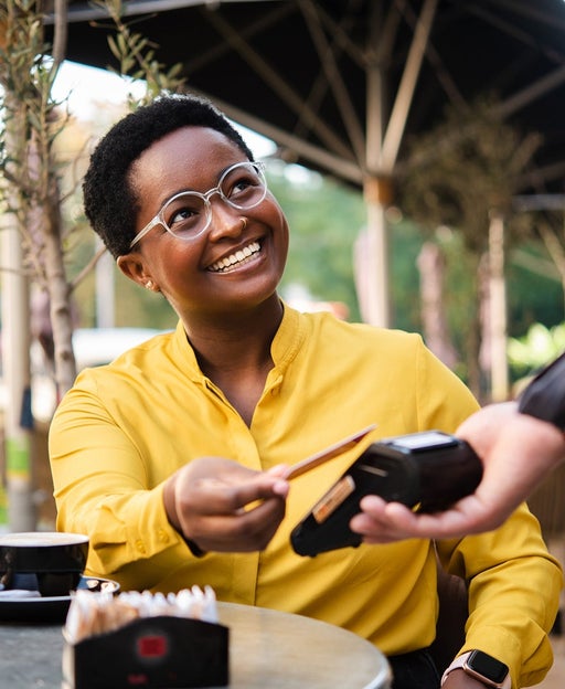 African American young woman paying with a credit card for her coffee