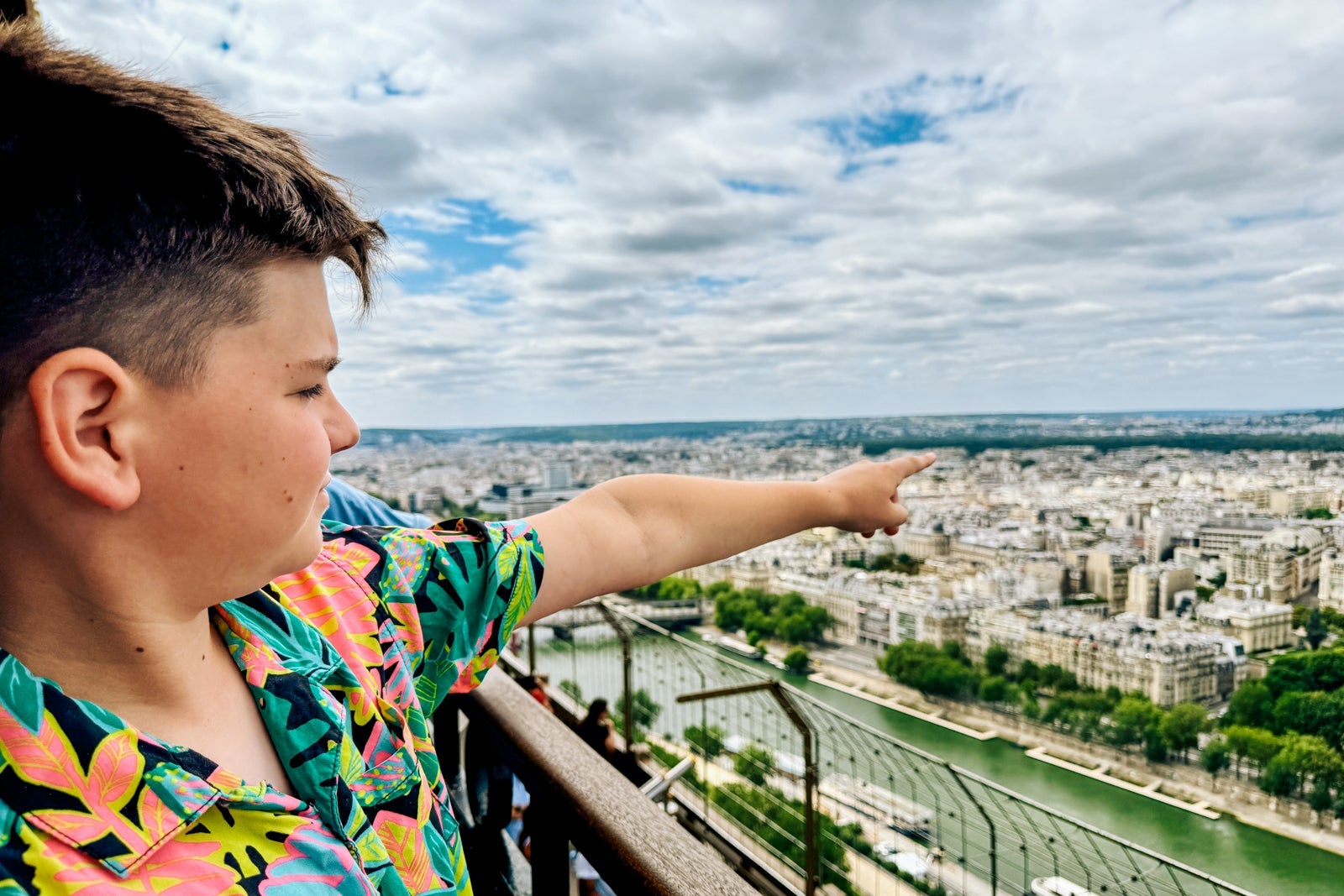 A boy pointing at Paris from the Eiffel Tower