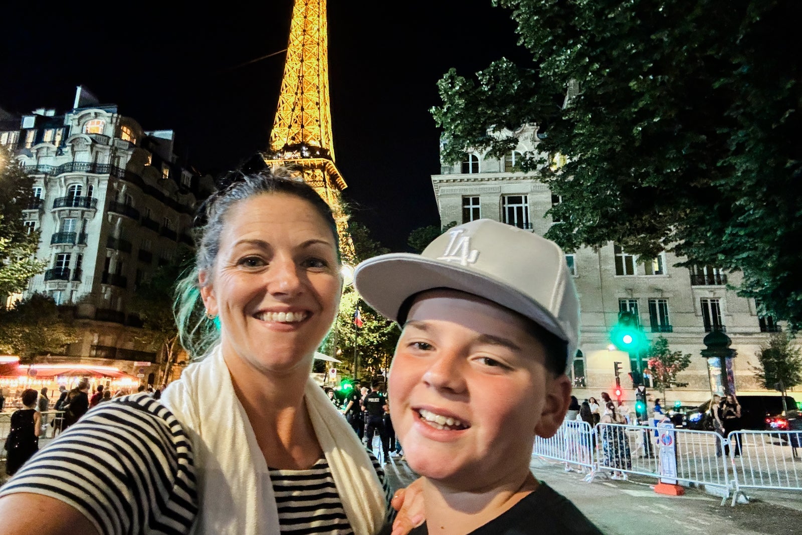 Tarah Chieffi and son posing in front of the Eiffel Tower at night