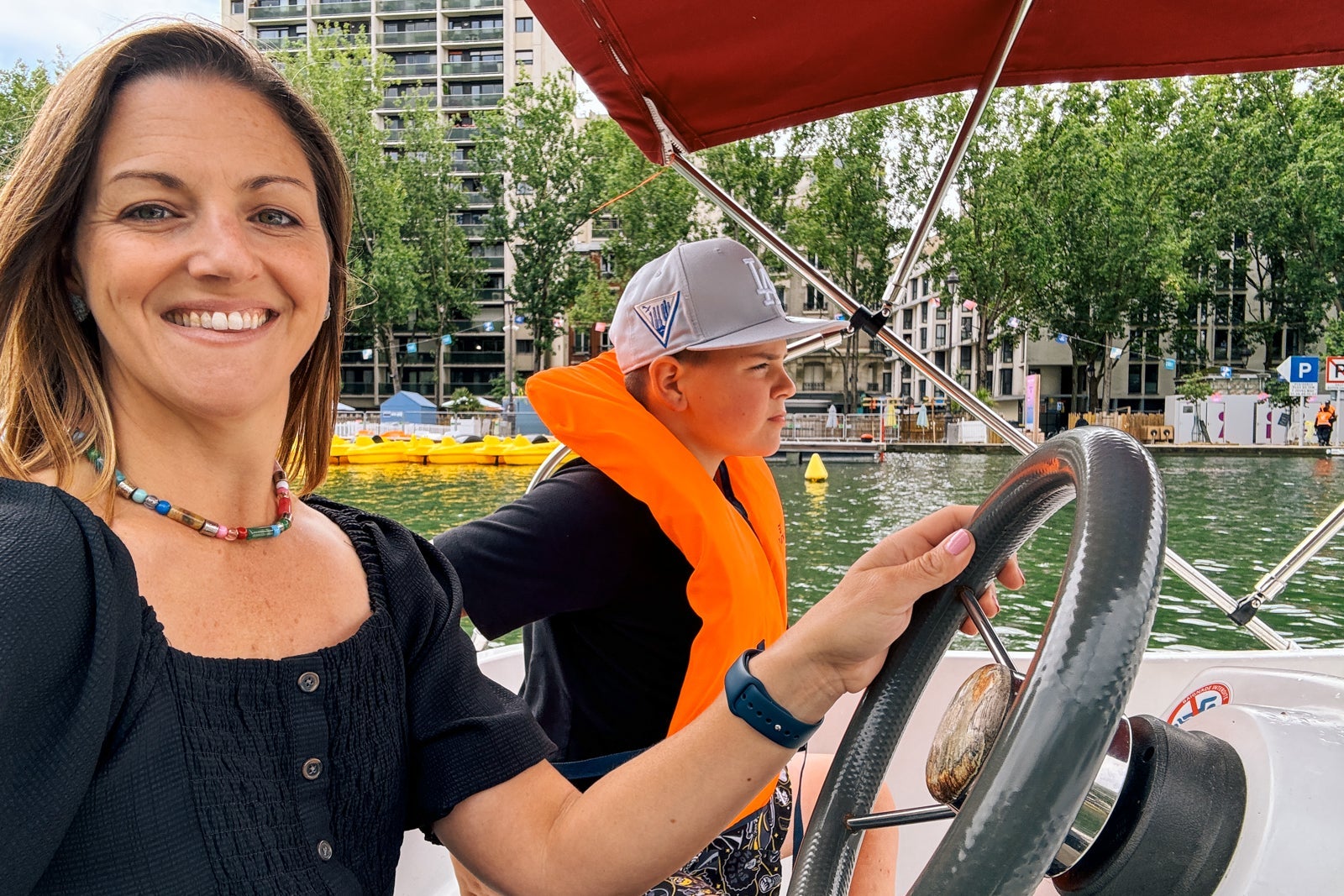 Tarah Chieffi and son driving on the Seine in an electric boat