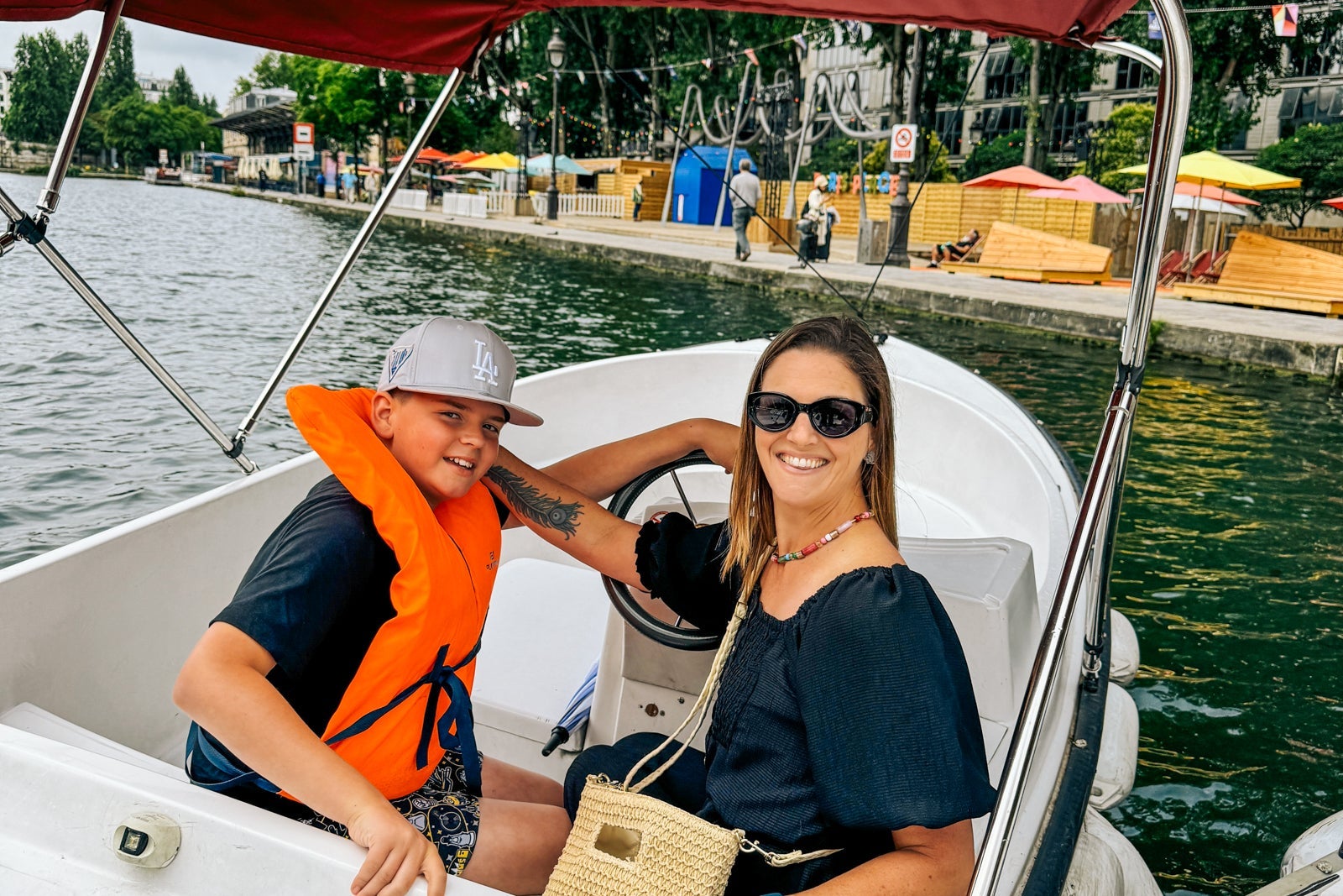 Tarah Chieffi and son driving on the Seine in an electric boat