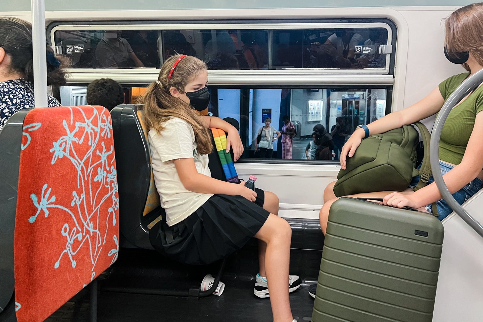 A girl sitting on a Paris subway
