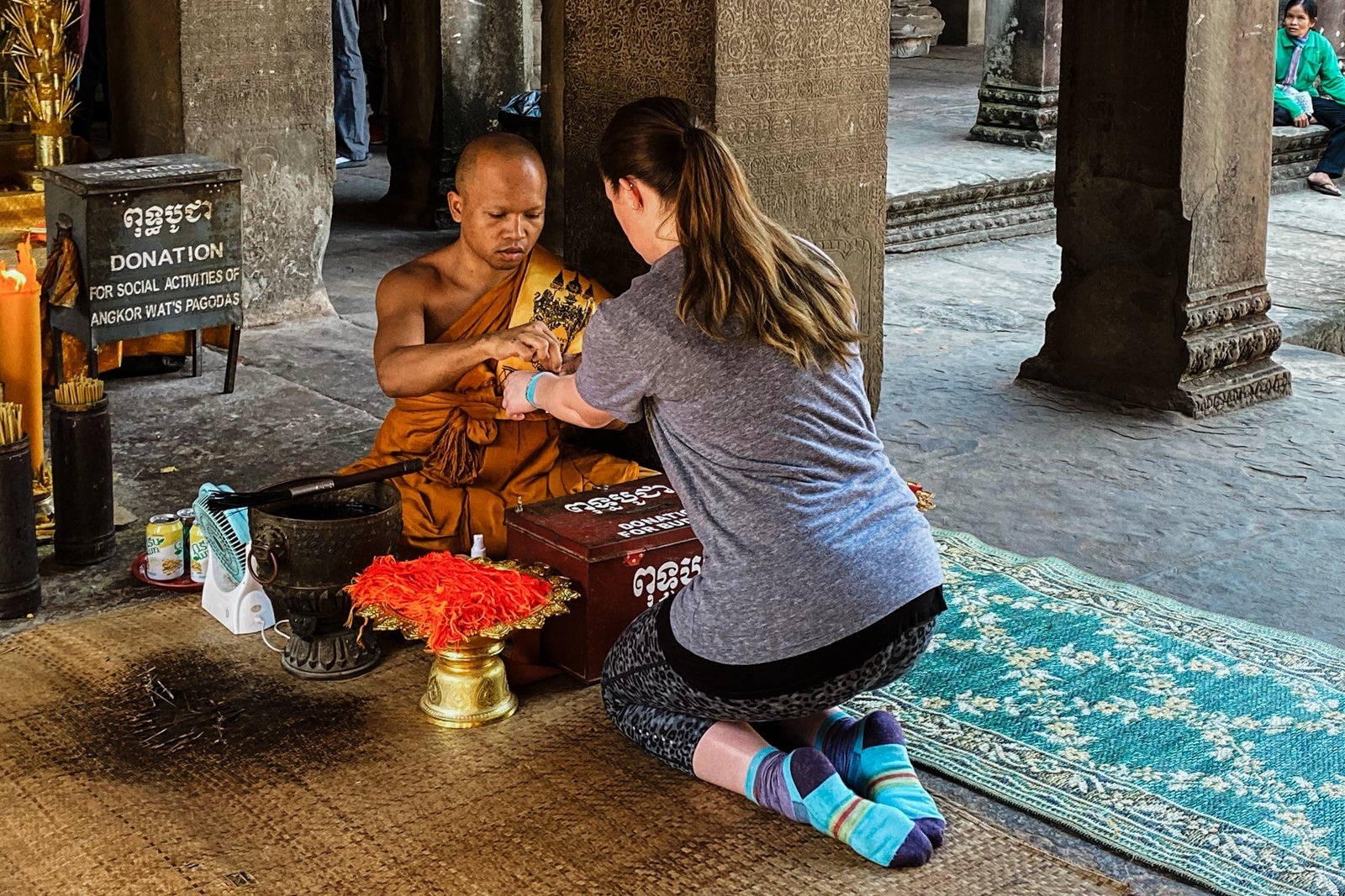 woman getting a blessing from a Buddhist monk at Ankgor Wat
