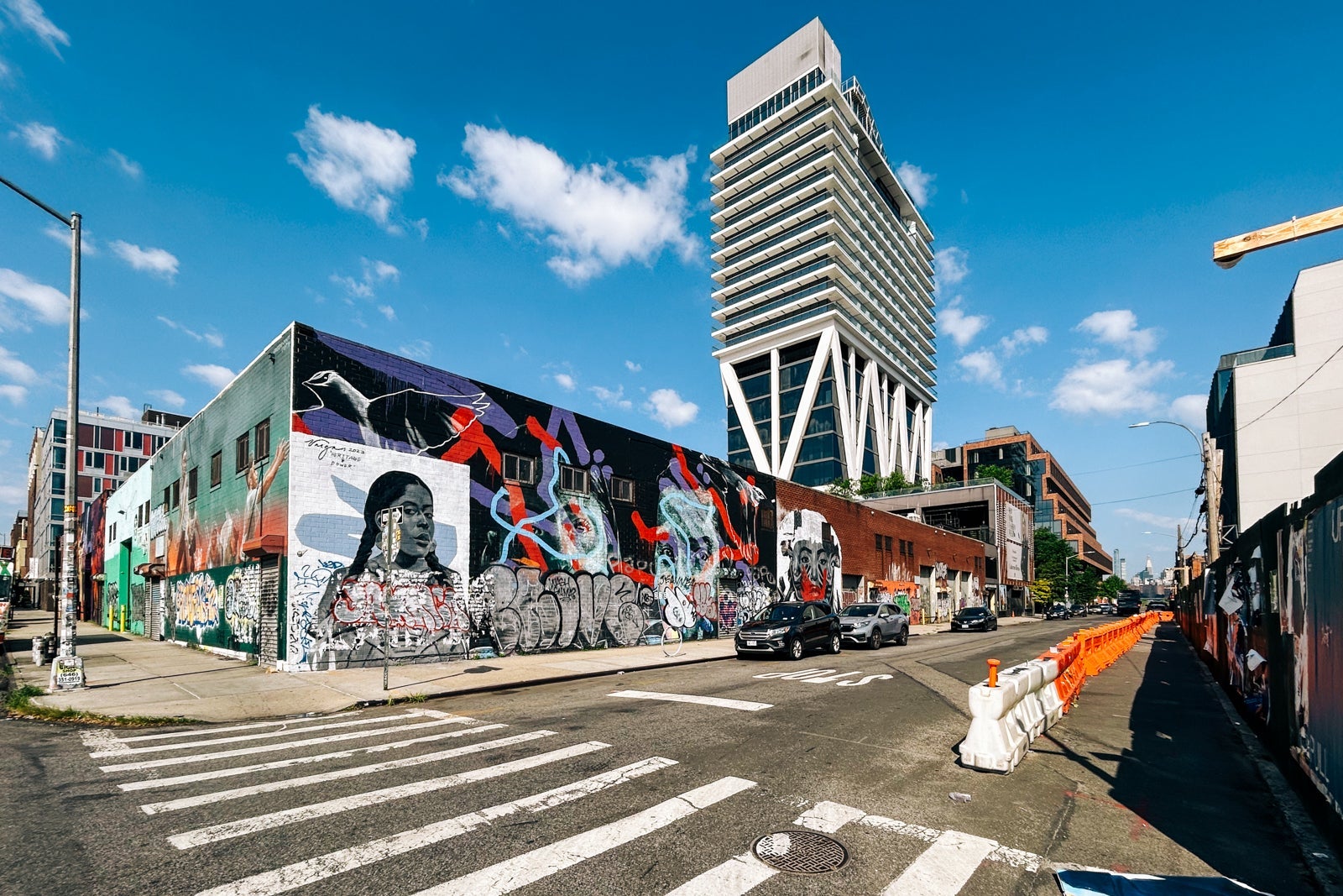 William Vale hotel tower behind wall of street art in Brooklyn