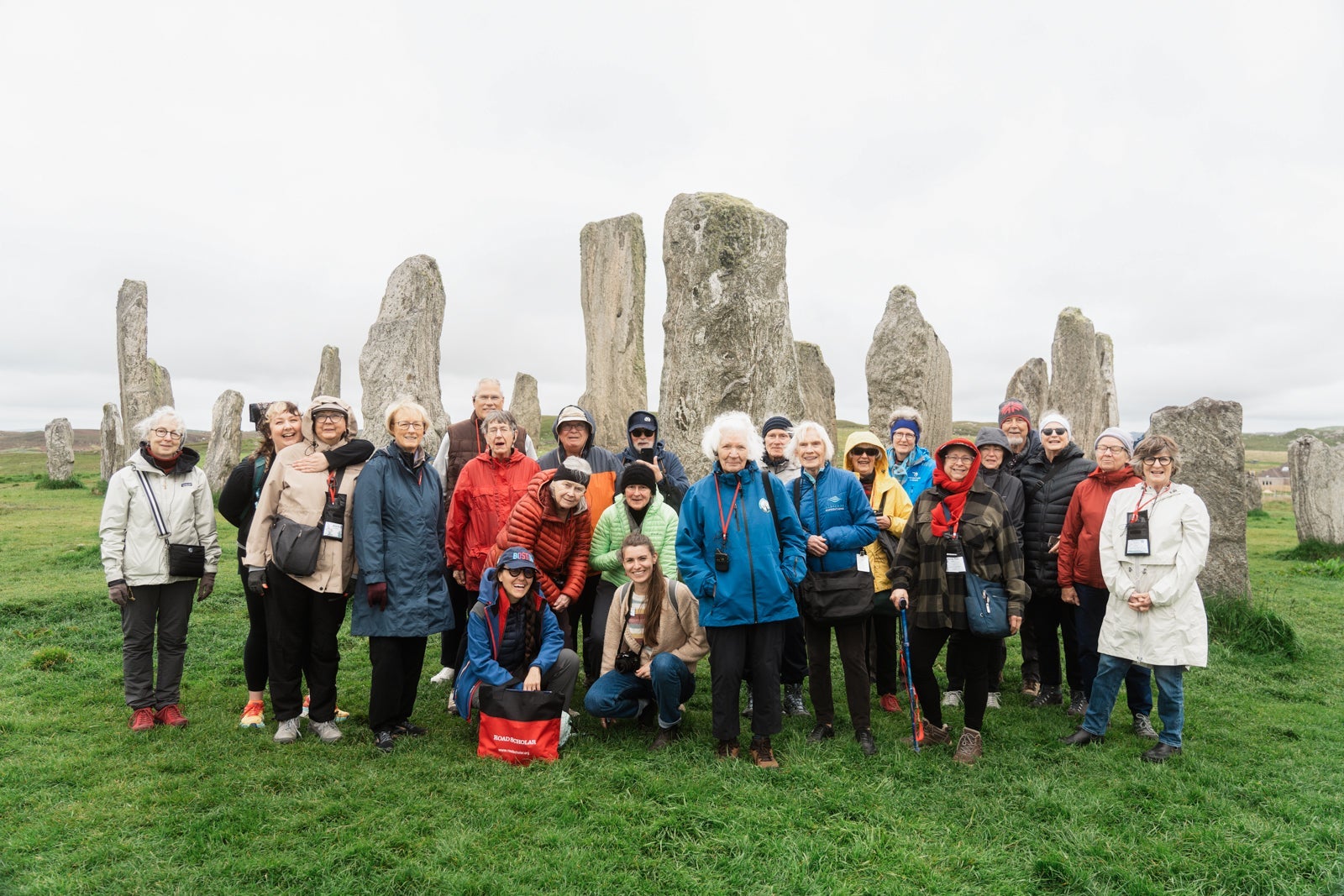 Group of travelers in front of standing stones in Scotland