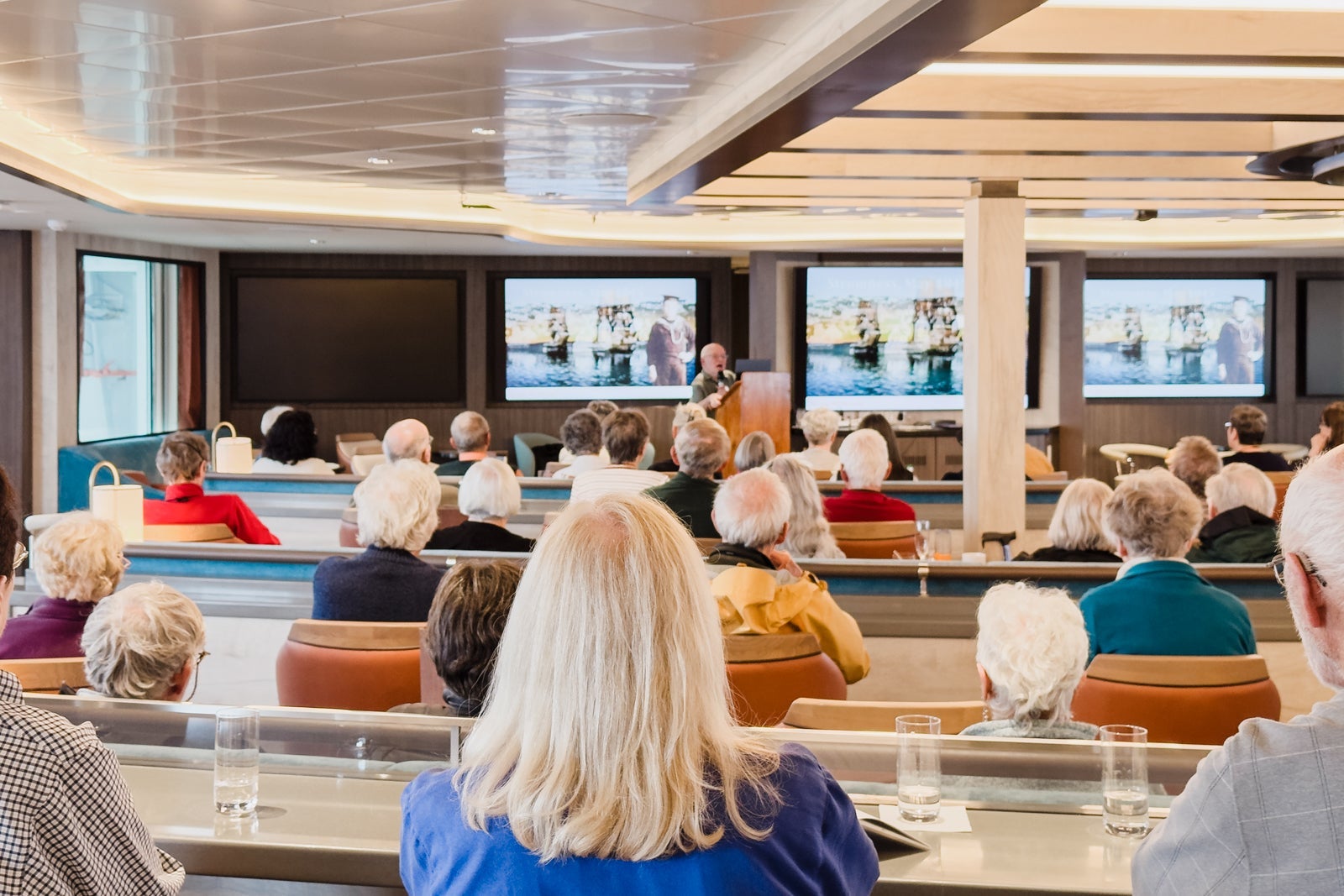 Cruise guests listen to onboard lecturer