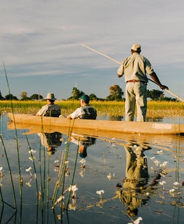 Three people in a canoe in the Okavango Delta