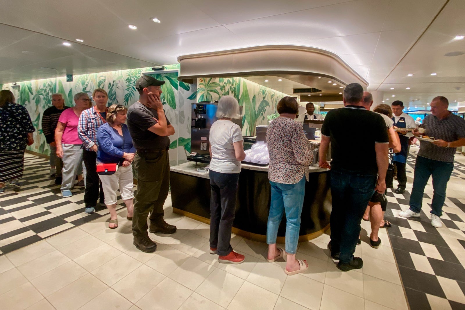 Queen Anne passengers wait in line for food at the ship's buffet eatery.