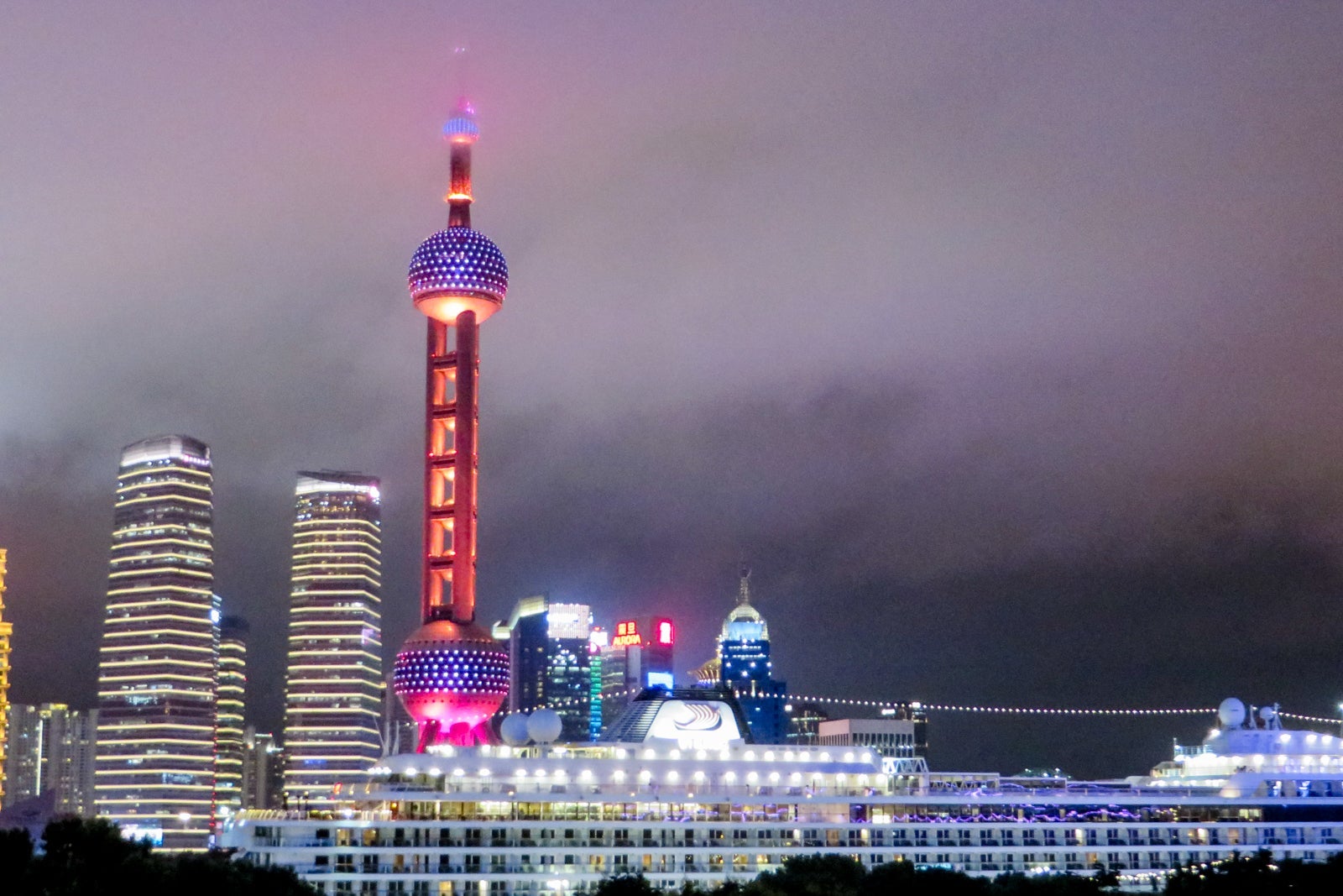 A cruise ship docked against the skyline in Shanghai, China