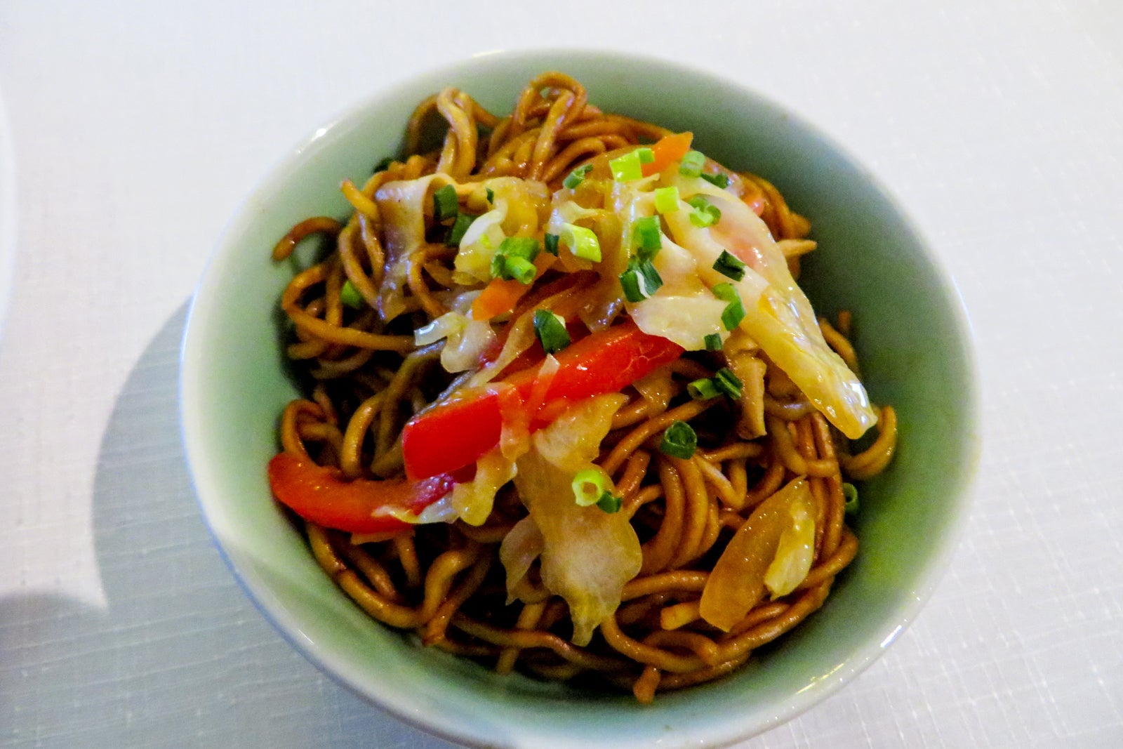 A bowl of Chinese dandan noodles topped with vegetables