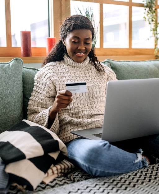young person on laptop with card