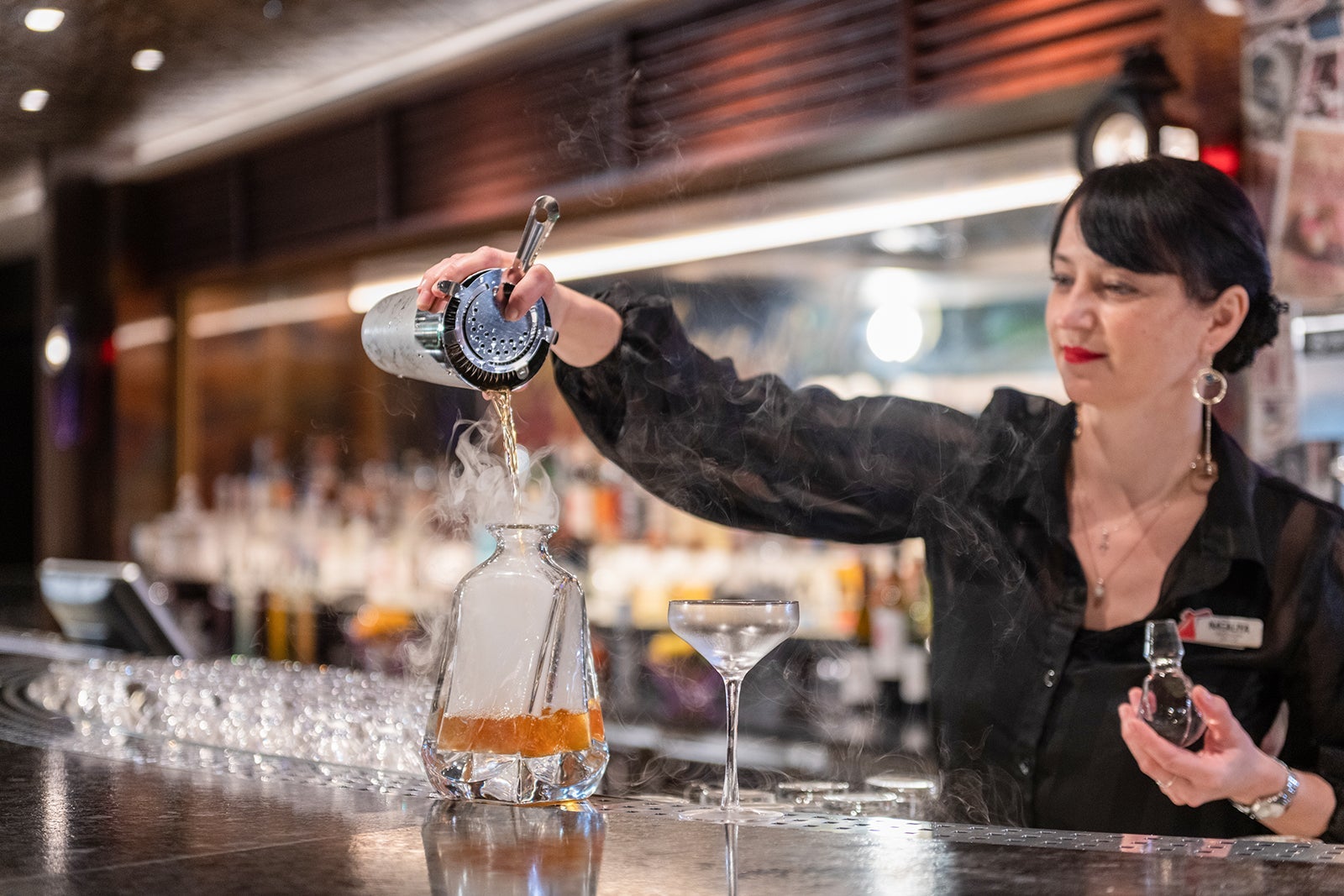 A bartender makes a drink at the Fortune Teller Bar on Carnival's Mardi Gras cruise ship
