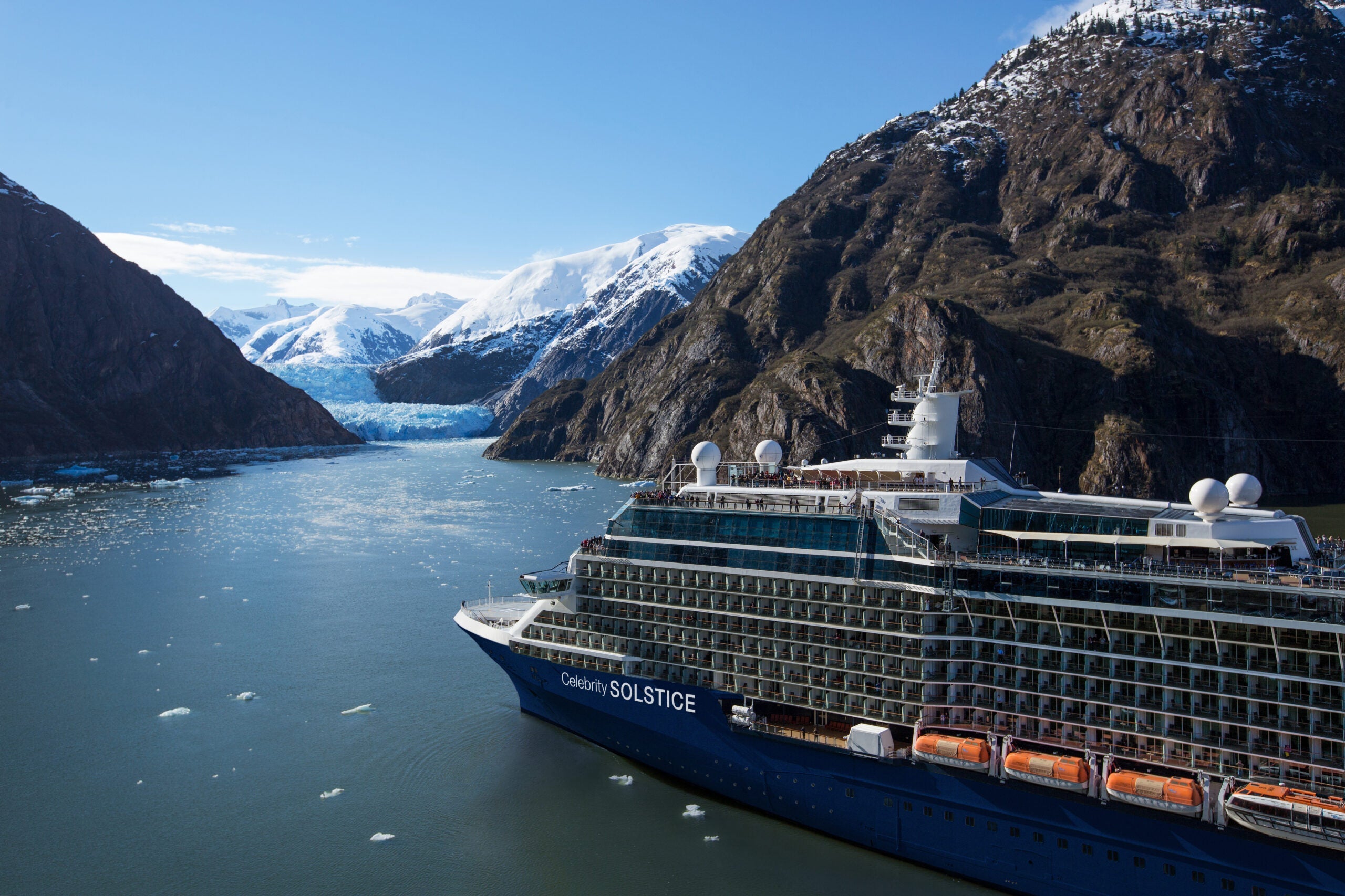 Celebrity Cruises ship sailing through Alaska with mountains in the background