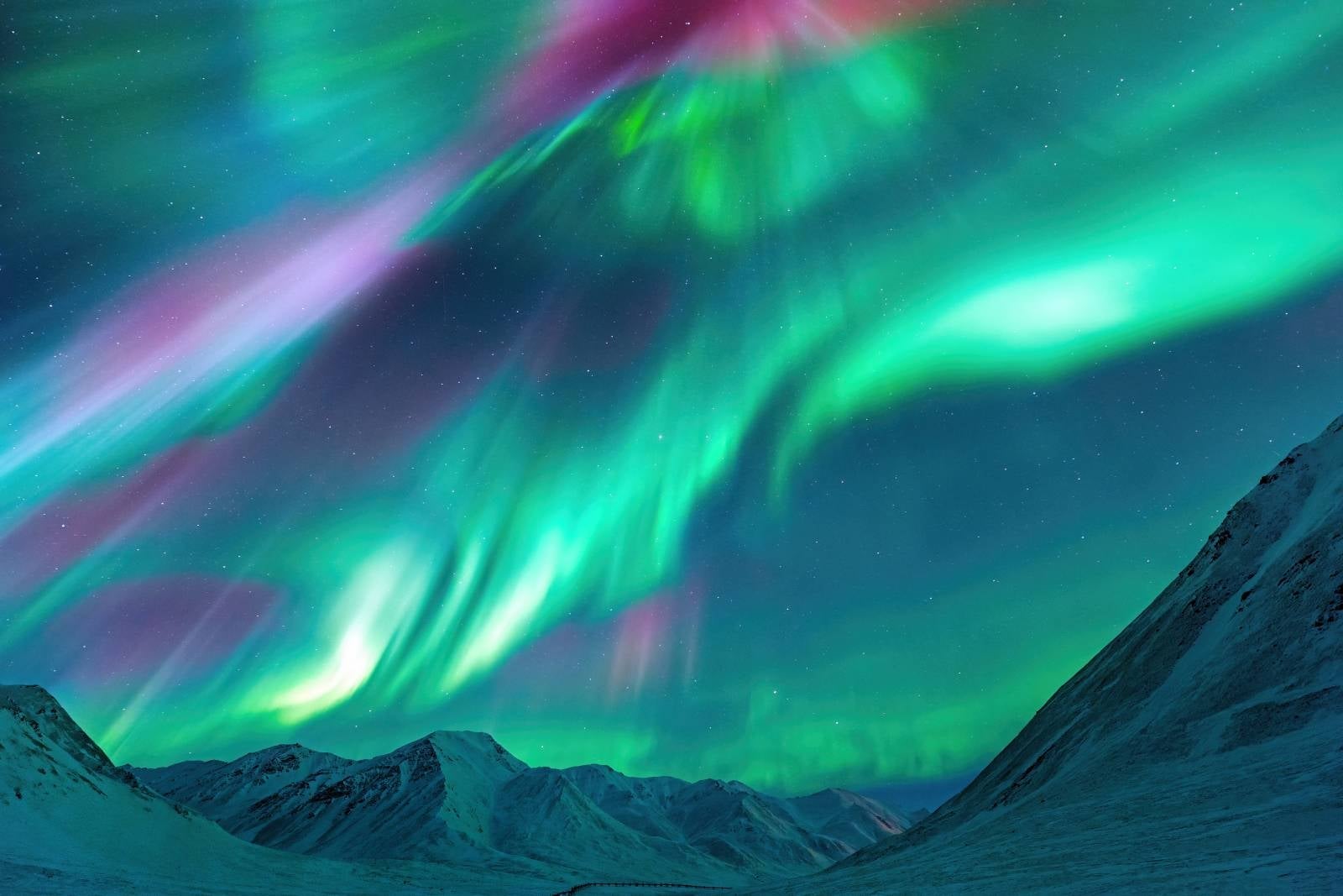 Strong Kp index Aurora Borealis (Northern Lights) exploding over the Alaskan peaks near Atigun Pass along the Dalton Highway, located to the north of Fairbanks, Alaska, USA.