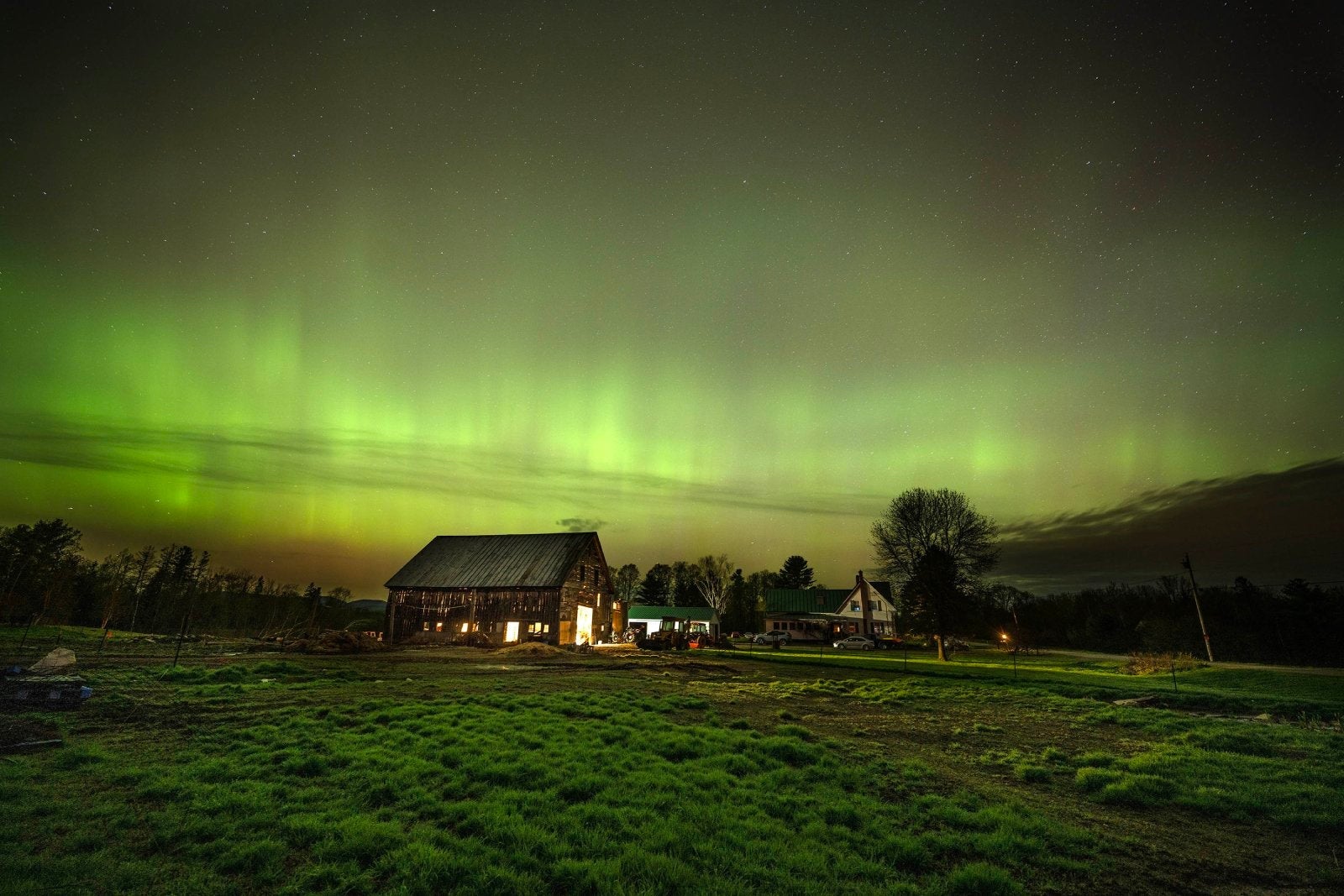 MERCER, MAINE - MAY 11, 2024 The northern lights fill the sky with green ribbons of electrical charged particles over the barn and pastures at Greaney's Turkey Farm in Mercer, Maine on May 11, 2024. The aurora borealis, commonly referred to as the northern lights, are electrically charged particles that are interacting with gases in outer space. This recent display was the strongest seen since 2003 rating a G5 on the geomagnetic scale.