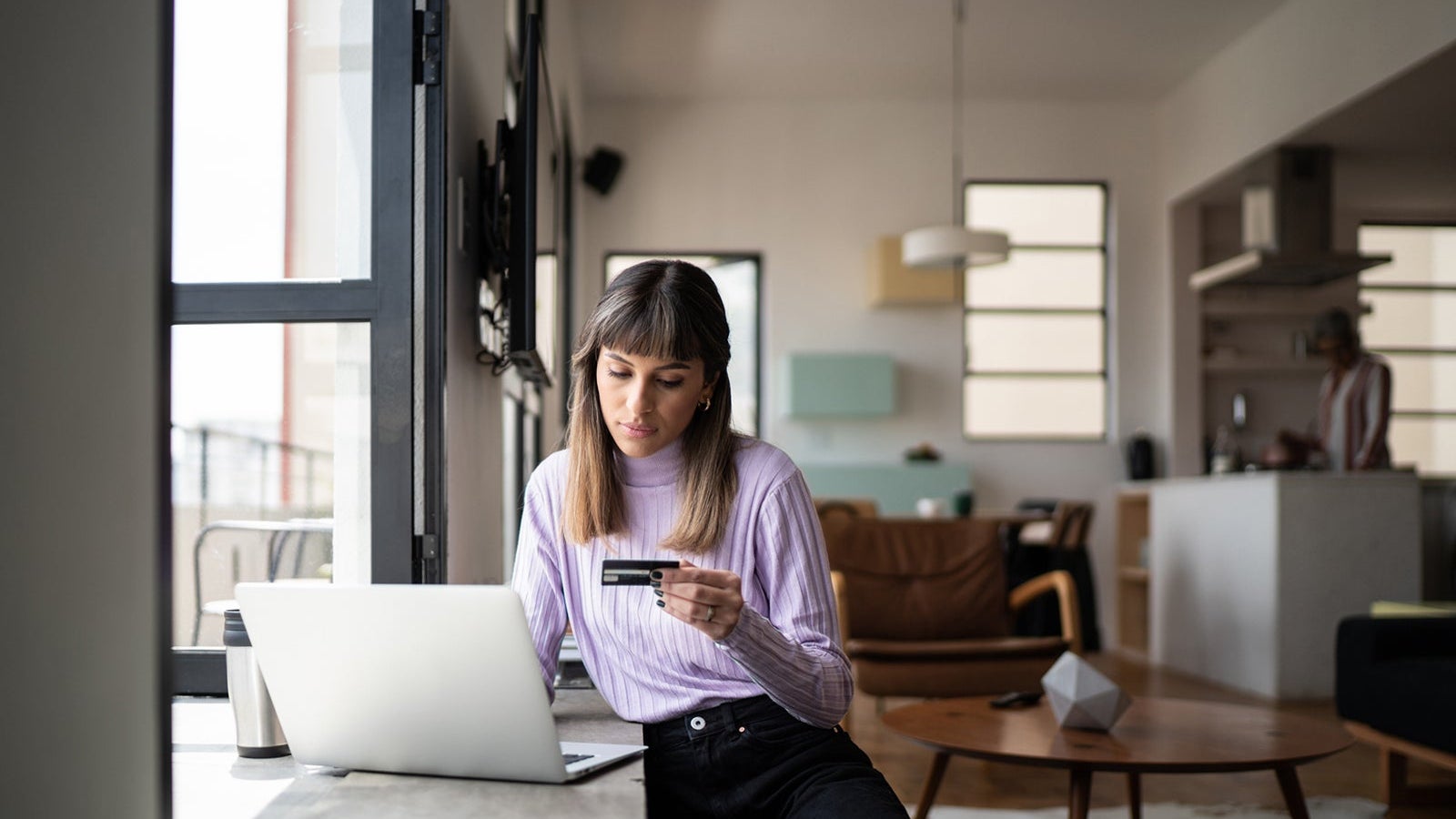 Young woman doing online shopping using credit card at home